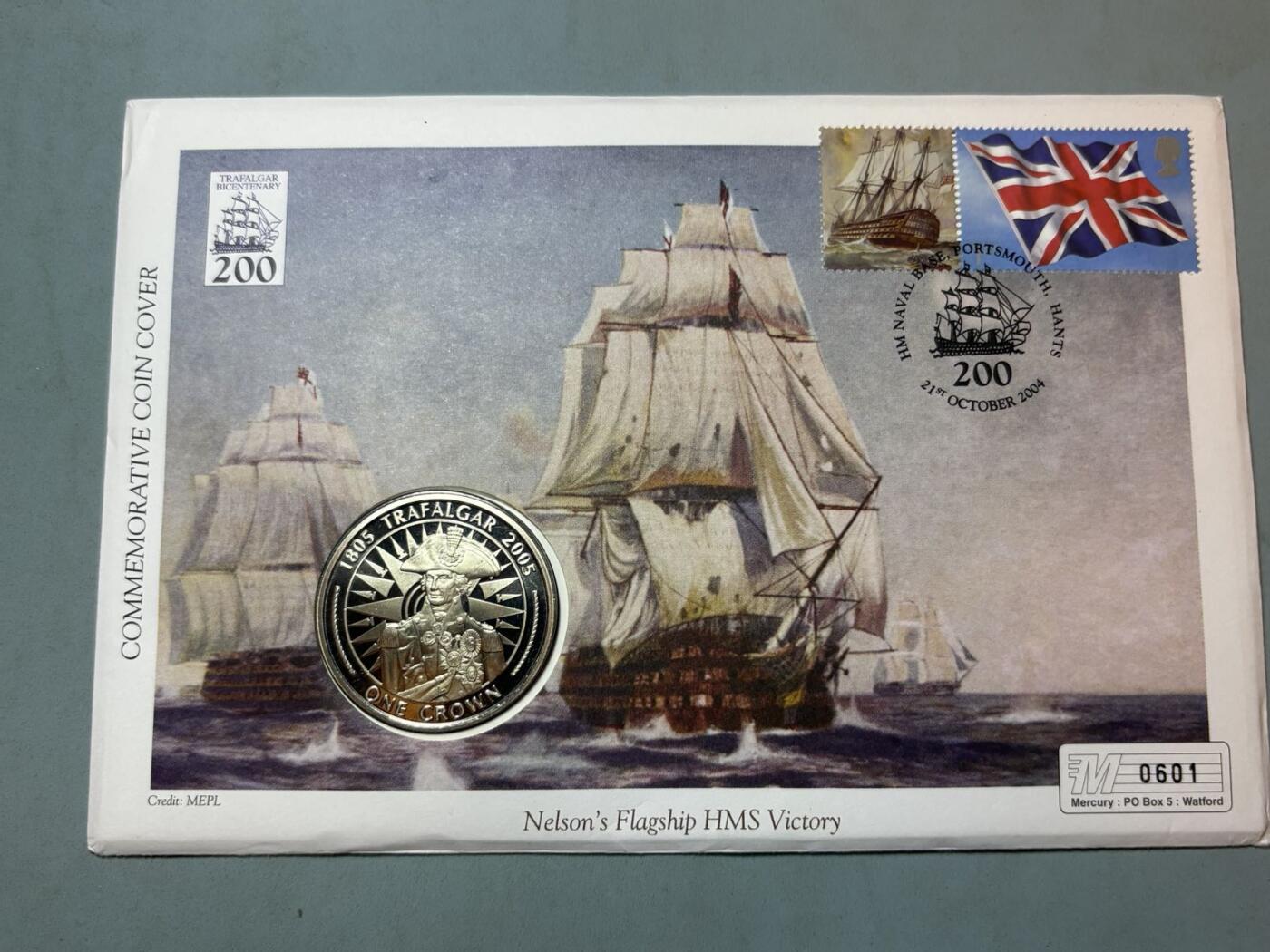 盛世勋华——号角文化勋章邮票专场拍卖第291期 英国马恩岛2005年特拉法尔加海战200周年纪念币首日收藏封，含邮票、插画、克朗型纪念币封装，限量发行，编号0601，纪念1805年英国海军在特拉法尔加海战中击败法西联合舰队的战役，主角是英国海军名将纳尔逊的旗舰“胜利号（HMS Victory）”，2005年是该战役200周年纪念节点。
