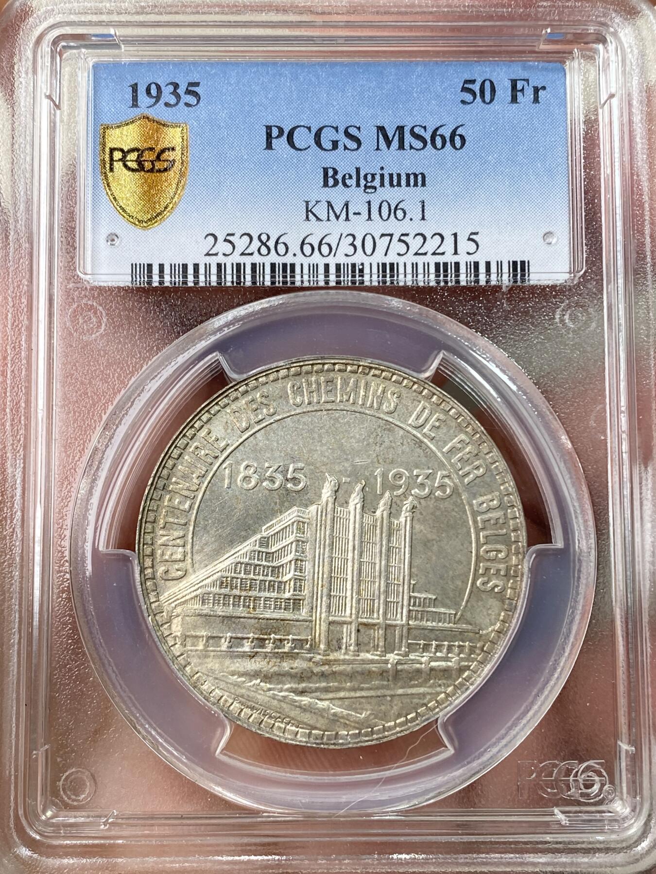 万国钱币拍卖第056期 PCGS MS66 1935年比利时50法郎纪念银币 布鲁塞尔国际博览会和比利时铁路百年 高分顶级品相 From the Roark Collection 原银强车轮霜光，黄油淡彩包浆，实物非常漂亮。正面:前卫设计的圣乔治屠龙，法语版铭文。背面:布鲁塞尔世博会大楼景观。边铭:SOUS LE REGNE DU ROI LEOPOLD III，在利奥波德三世国王的统治下。比利时皇家铸币厂。