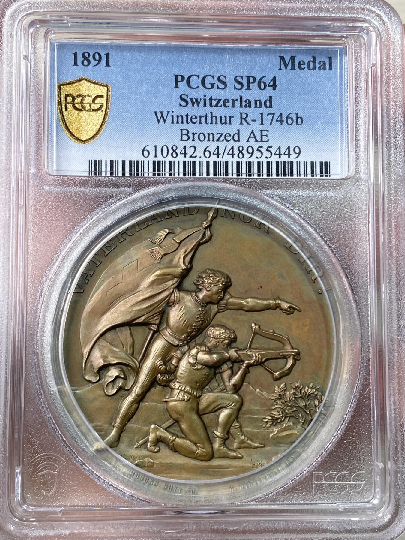 万国钱币拍卖第056期 PCGS SP64 1891年瑞士苏黎世铜章 温特图尔射击节 高浮雕加厚盒 正面:指挥官手握瑞士国旗，指向前方，放箭放箭～跪着的战士正用十字弓瞄准，背景是山地风景。背面:温特图尔的加冕城市纹章，长有翅膀的小天使头像，周围装饰有花环。高分顶级状态，设计极佳，实物非常漂亮。大尺寸铜章，新评几乎都是超大盒子，此枚收纳观赏更为合适。