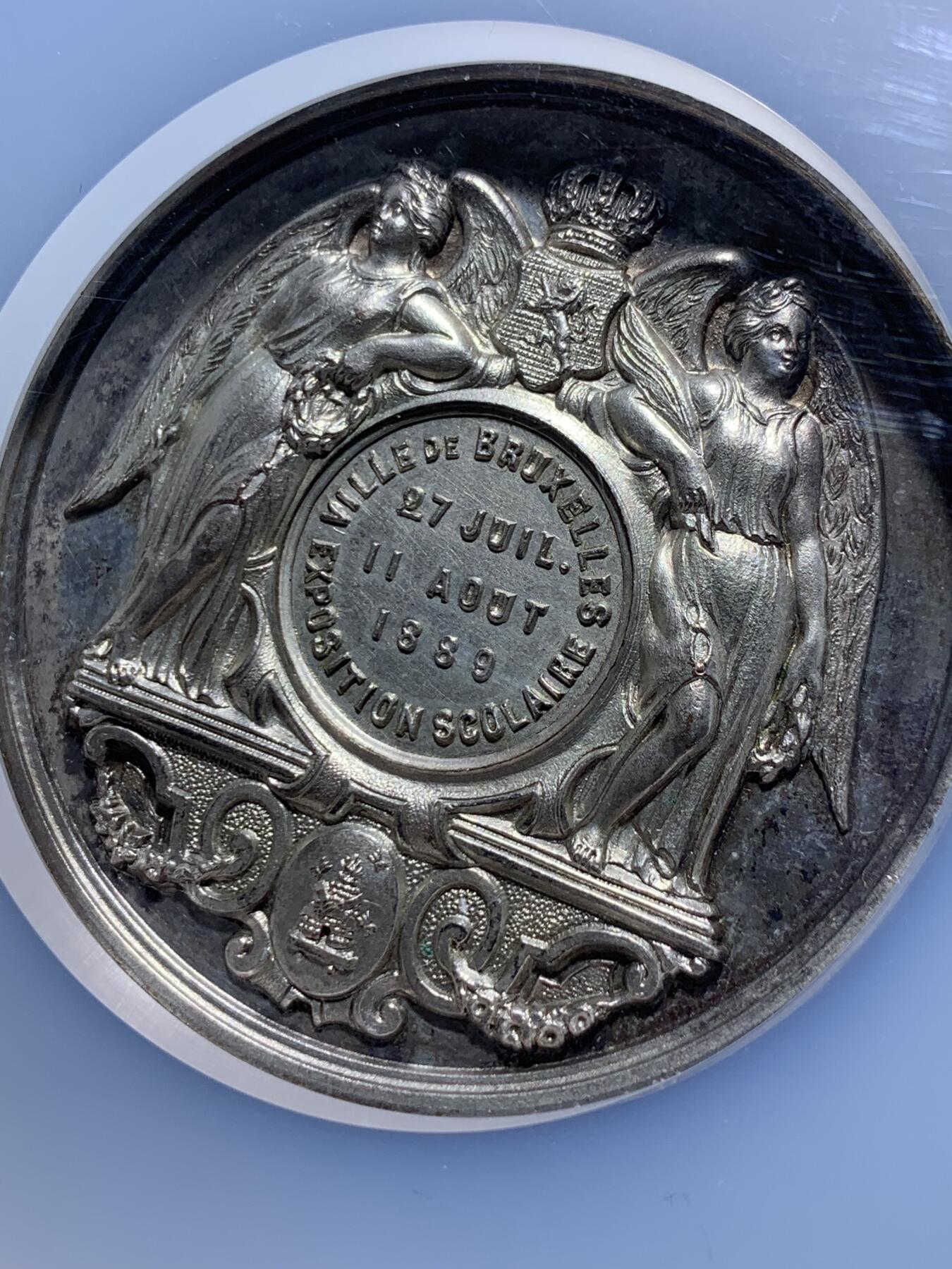 《竞宝斋》第443场 周日，周一，2场连拍 （全场包邮） NGC MS63 高分 1889年布鲁塞尔博览会 SCOLAIRE翼女神镀银铜章，双面高浮雕，细节立体，首见品，加大加厚盒。