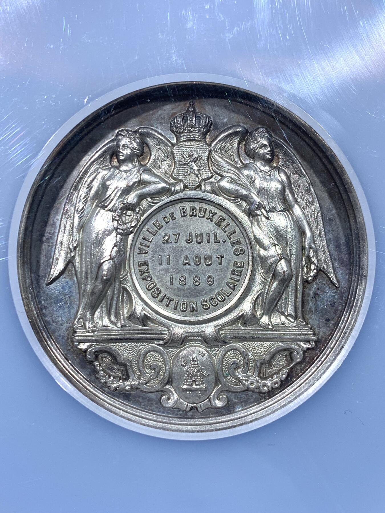 《竞宝斋》第443场 周日，周一，2场连拍 （全场包邮） NGC MS63 高分 1889年布鲁塞尔博览会 SCOLAIRE翼女神镀银铜章，双面高浮雕，细节立体，首见品，加大加厚盒。