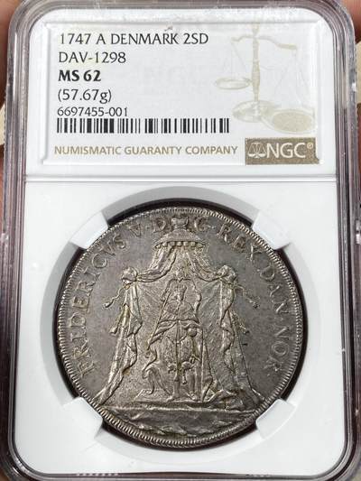 万国钱币拍卖第056期 - NGC MS62 1747丹麦弗雷德里克五世加冕2达勒大银 极其罕见的北欧加厚品种 57g非常压手 类似荷兰加厚马剑的手感 打制周正 斜齿边非常漂亮 极具特色的双野人护盾 双面均匀原味的包浆代表着其多年未被动过的状态 一步到位的典藏级品质