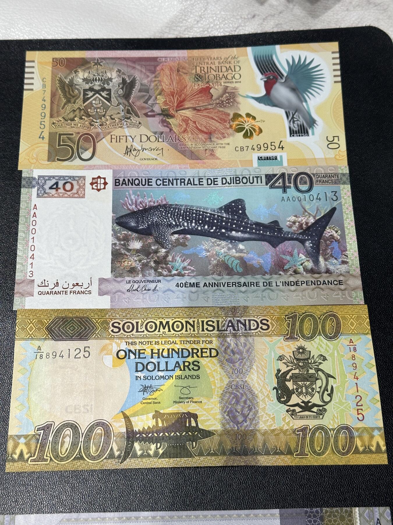 《外钞收藏家》第五百九十期（欧洲强钞、港币、硬通货及丰富裸币大拍场）（本平台长期征集拍品、欢迎藏友们联系合作） 特里达尼亚和多巴哥50+吉布提40两张纪念钞+所罗门群岛100 三张一起 全新UNC