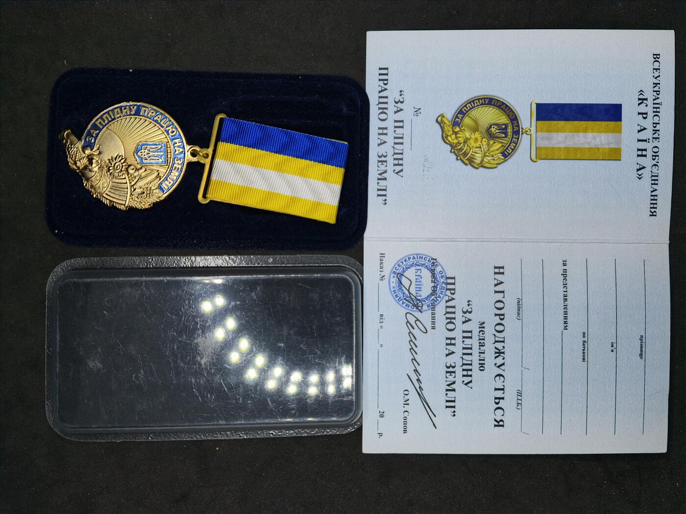 凯旋世界勋赏（第20期）（欢迎送拍）（对拍品有疑问请询问客服，不接受到手刀，出价默认拍品品相。请认真阅读拍卖规则！出价默认已认可！）（收到货请录制开箱视频，无视频概不处理问题。） 乌战卓越工作奖章，爱国者组织颁发，带证，奖励农民辛勤工作，文字为“表彰为故乡卓有成效的工作”