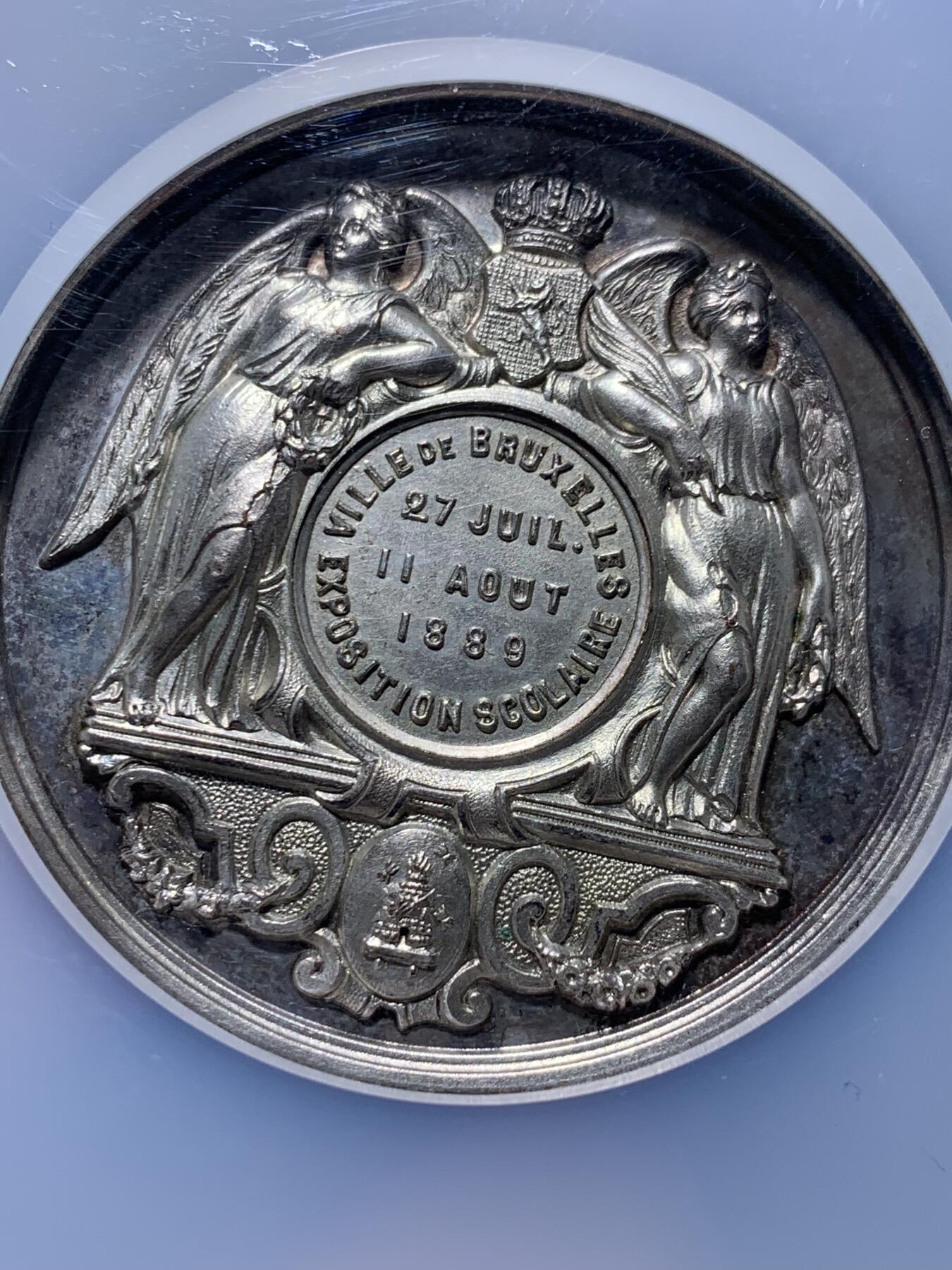 《竞宝斋》第443场 周日，周一，2场连拍 （全场包邮） NGC MS63 高分 1889年布鲁塞尔博览会 SCOLAIRE翼女神镀银铜章，双面高浮雕，细节立体，首见品，加大加厚盒。