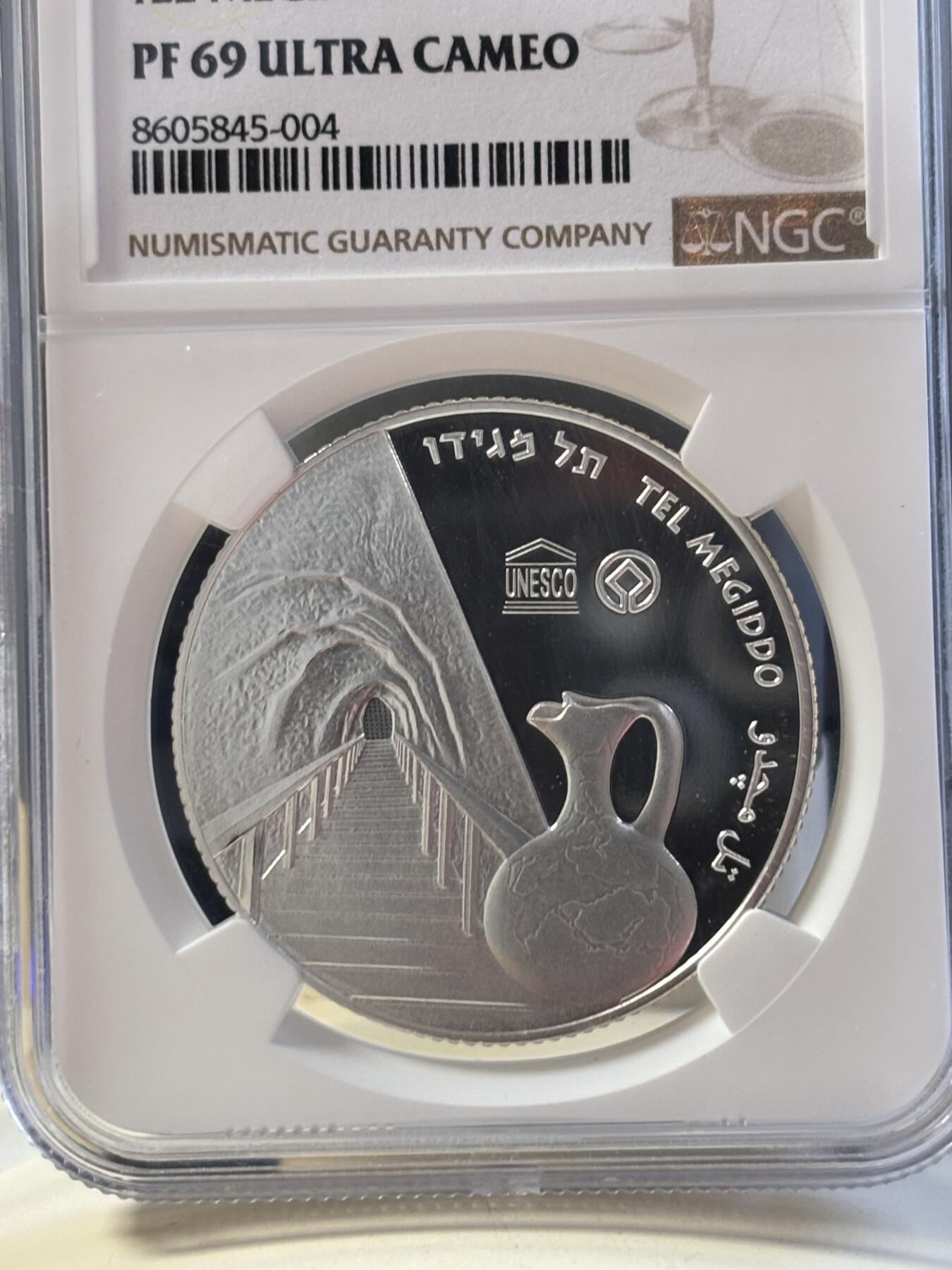 第183期拍卖 以色列2012年圣经系列美吉多山2新谢克尔PROOF银币NGC PF69UC，发行量3000枚，999银。美吉多山是《圣经·启示录》中世界末日善与恶最终决战之地，正面设计陶壶和山谷，通过透视图技法，尤其是山谷及通向内部的栈道，给人一种向里走的感觉，在二维平面银币表现出三维立体効果。原盒证封齐全。