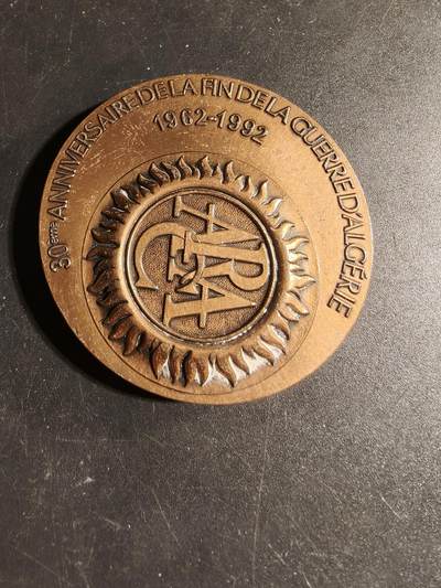 老王徽章第167期 - 法国退伍军人、战争受害者和战争之友协会阿尔及利亚战争30周年大铜章       高浮雕      正面描绘了和平鸽飞越被战争摧毁的城镇上空，背景是废墟和一片墓地，象征着对战争的控诉和对和平的渴望      直径 54mm.     重量104.1g