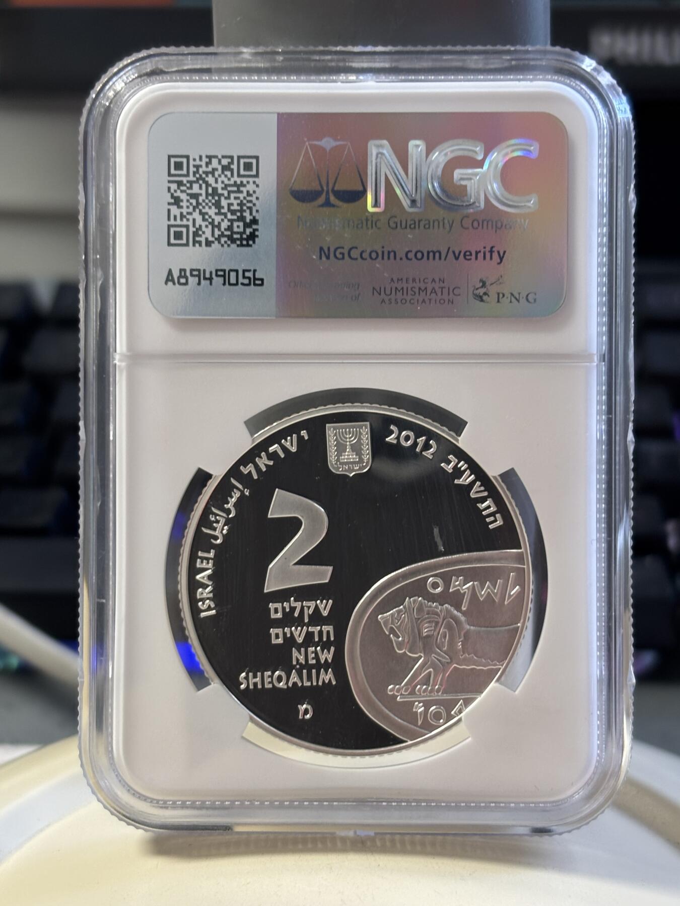 第183期拍卖 以色列2012年圣经系列美吉多山2新谢克尔PROOF银币NGC PF69UC，发行量3000枚，999银。美吉多山是《圣经·启示录》中世界末日善与恶最终决战之地，正面设计陶壶和山谷，通过透视图技法，尤其是山谷及通向内部的栈道，给人一种向里走的感觉，在二维平面银币表现出三维立体効果。原盒证封齐全。