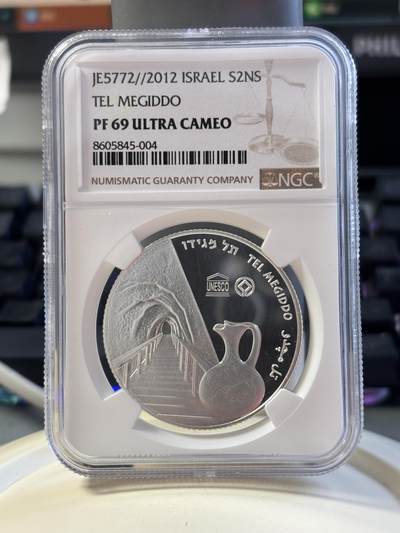 第183期拍卖 - 以色列2012年圣经系列美吉多山2新谢克尔PROOF银币NGC PF69UC，发行量3000枚，999银。美吉多山是《圣经·启示录》中世界末日善与恶最终决战之地，正面设计陶壶和山谷，通过透视图技法，尤其是山谷及通向内部的栈道，给人一种向里走的感觉，在二维平面银币表现出三维立体効果。原盒证封齐全。