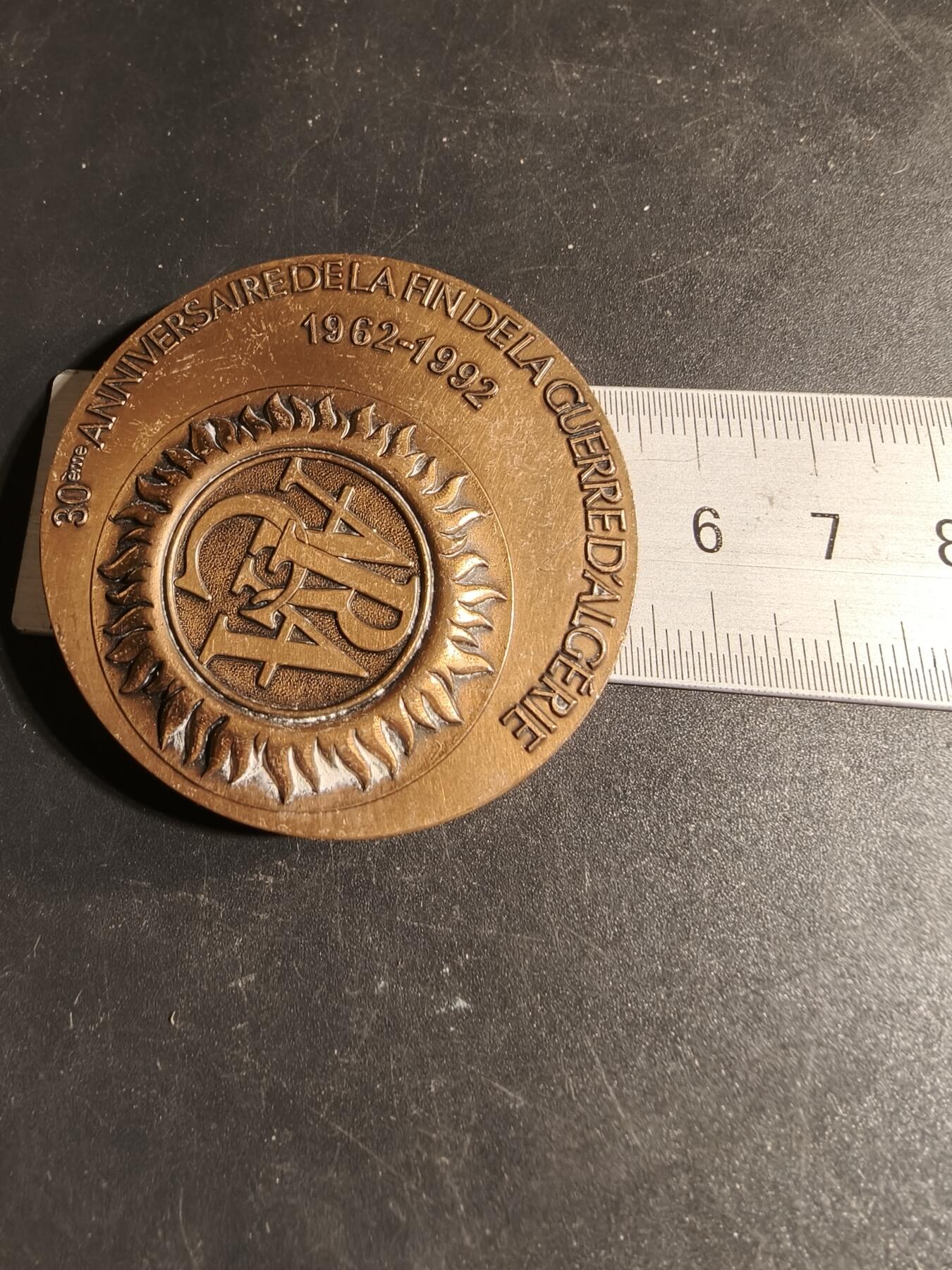 老王徽章第167期 法国退伍军人、战争受害者和战争之友协会阿尔及利亚战争30周年大铜章       高浮雕      正面描绘了和平鸽飞越被战争摧毁的城镇上空，背景是废墟和一片墓地，象征着对战争的控诉和对和平的渴望      直径 54mm.     重量104.1g