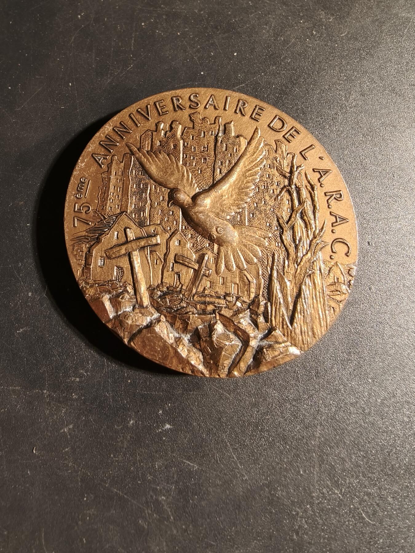 老王徽章第167期 法国退伍军人、战争受害者和战争之友协会阿尔及利亚战争30周年大铜章       高浮雕      正面描绘了和平鸽飞越被战争摧毁的城镇上空，背景是废墟和一片墓地，象征着对战争的控诉和对和平的渴望      直径 54mm.     重量104.1g