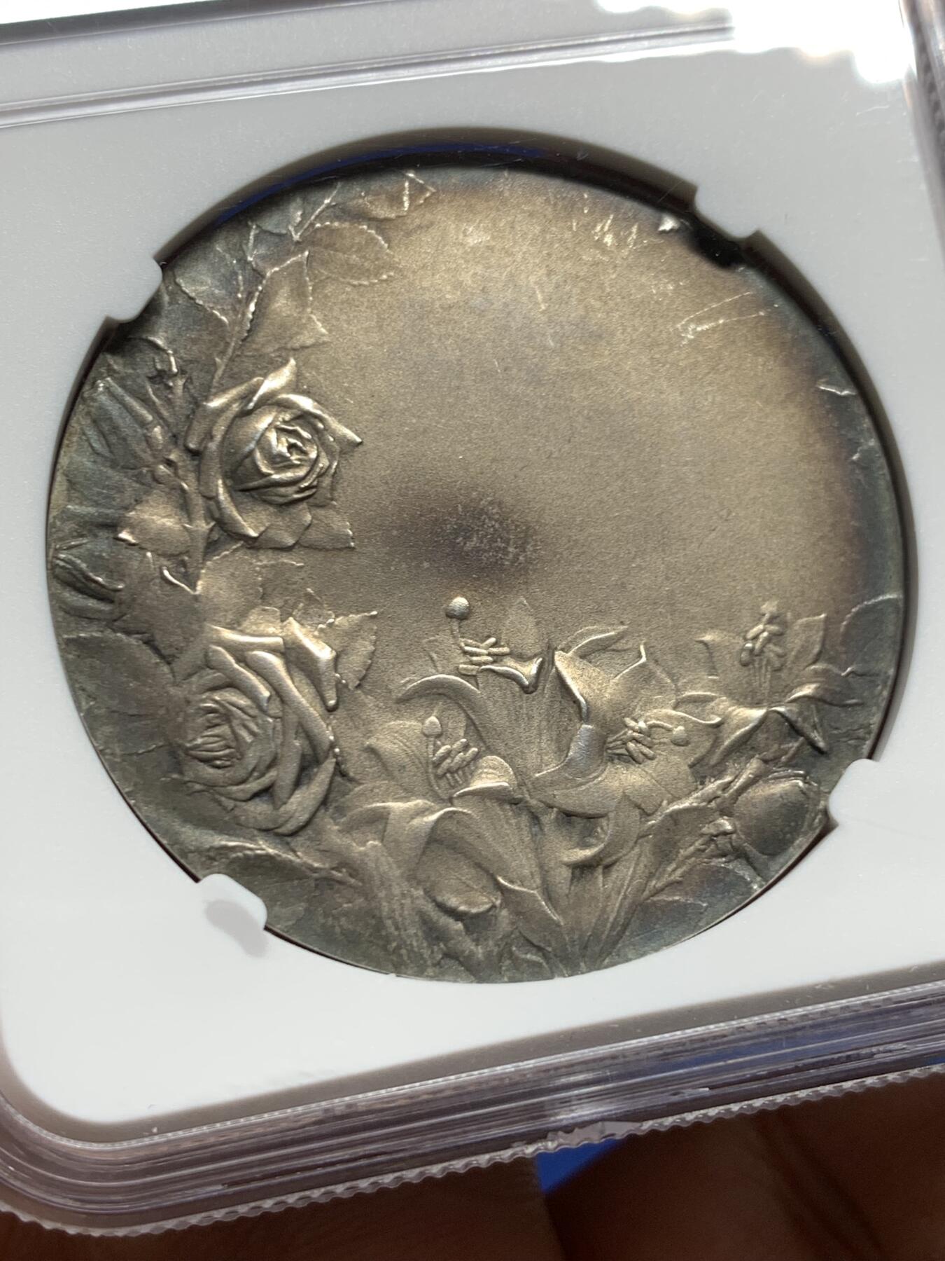 《竞宝斋》第444场 周日，周一，2场连拍 （全场包邮） NGC MS62 法国新艺术宗教婚礼稀有大银章，著名新艺术雕刻家：弗雷德里克-夏尔.维克托.德.韦尔农，以细腻的宗教题材浮雕著称。该章为更为稀少的背面无刻字版，适合新婚、结婚纪念刻字。正面场景：描绘yesu与使徒彼得、约翰（或抹大拉的马利亚）的互动FIDELI PERSTETIS AMORE拉丁语，意为**“你们对那忠信的恒守爱心”，背面：花卉：左下角的玫瑰（象征玛利亚的纯洁）与下方的百合（象征圣