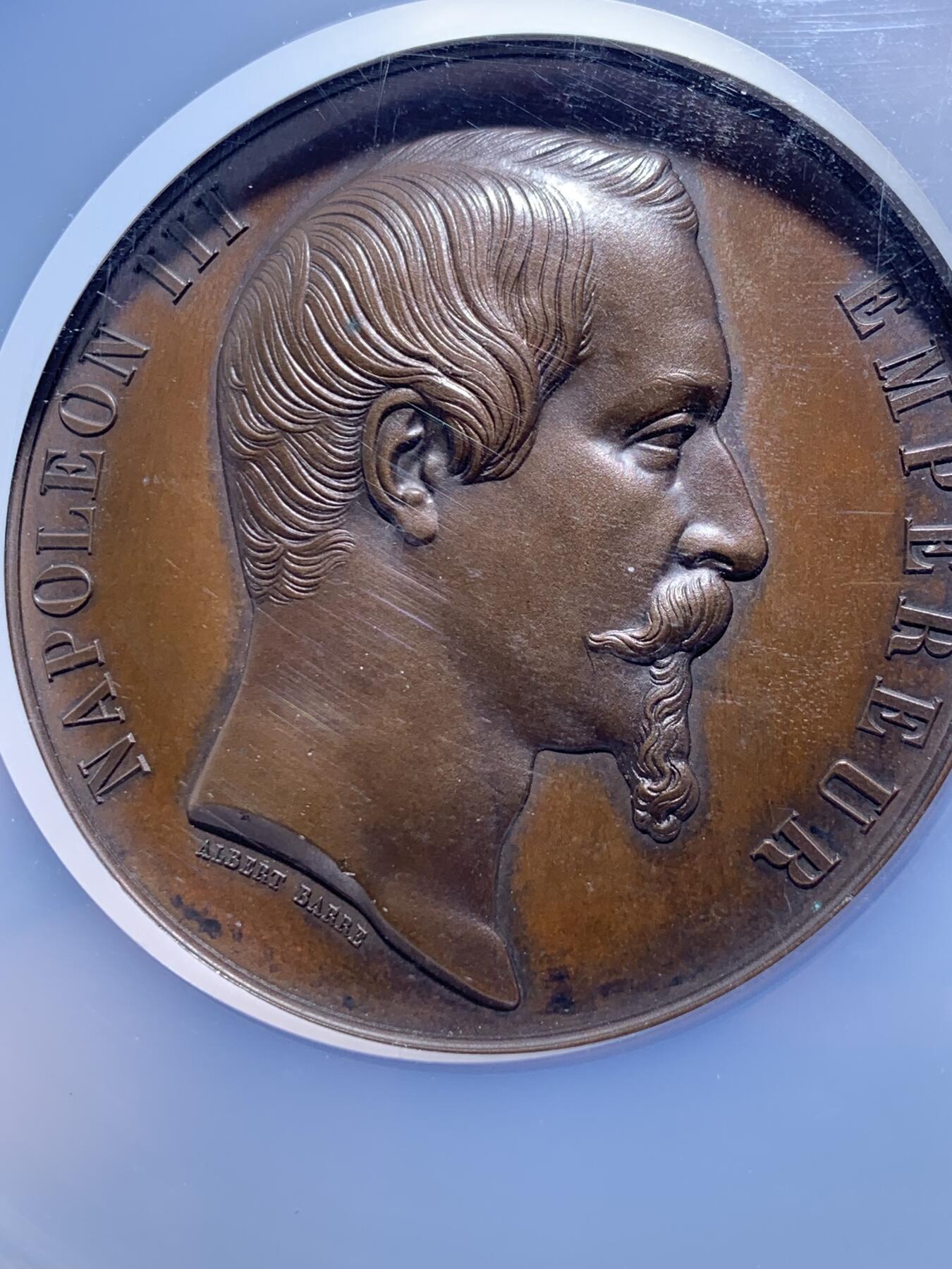 《竞宝斋》第444场 周日，周一，2场连拍 （全场包邮） NGC MS64BN 法国1855年巴黎世博会纪念大铜章，60mm，顶级高分。拿三章牌中的热门品种，20国徽章环绕波拿巴家族鹰徽，众星捧月，繁复华丽，记录拿破仑三世的巅峰时刻。手指边铭原铸品，加大加厚盒装