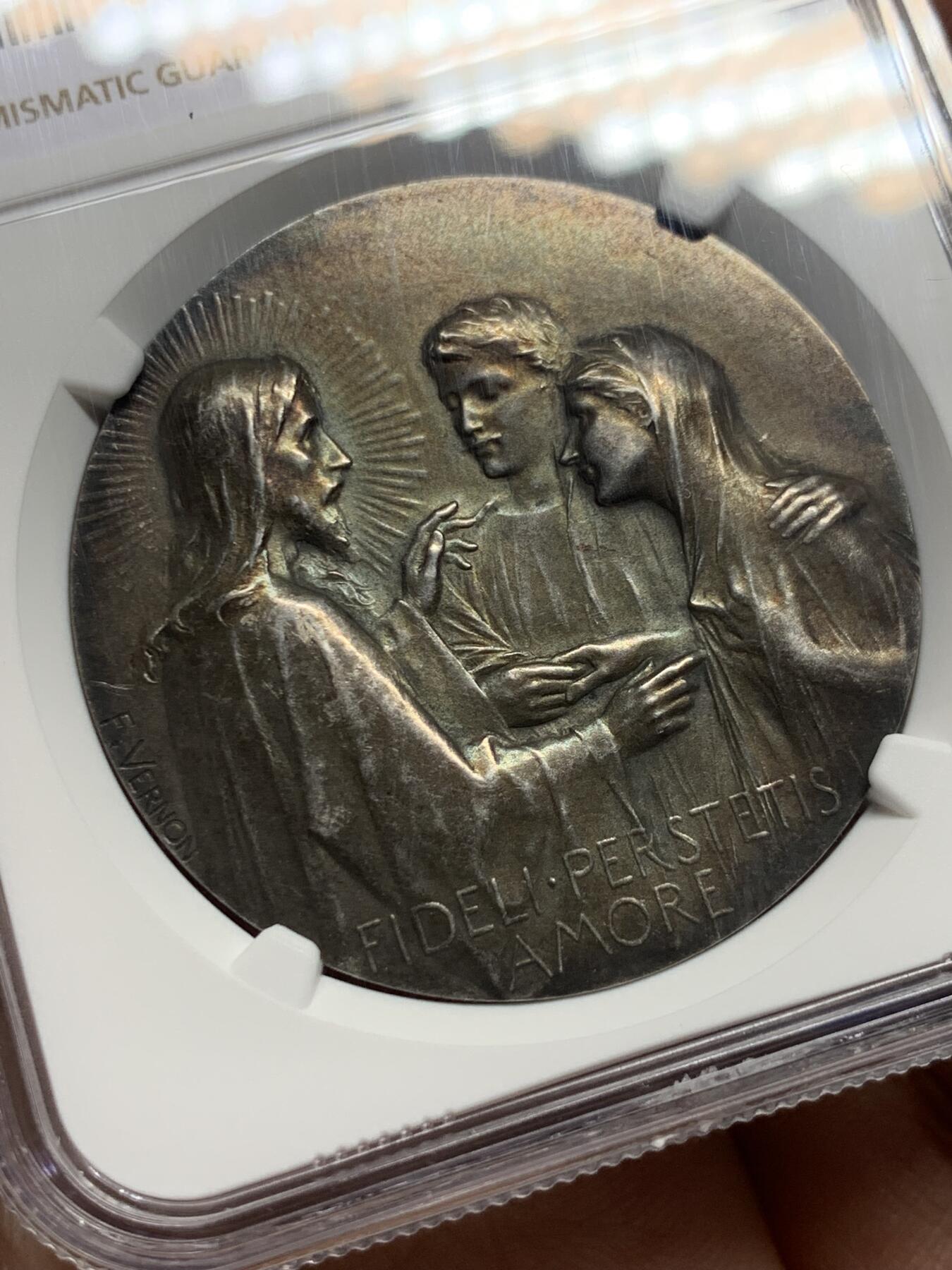 《竞宝斋》第444场 周日，周一，2场连拍 （全场包邮） NGC MS62 法国新艺术宗教婚礼稀有大银章，著名新艺术雕刻家：弗雷德里克-夏尔.维克托.德.韦尔农，以细腻的宗教题材浮雕著称。该章为更为稀少的背面无刻字版，适合新婚、结婚纪念刻字。正面场景：描绘yesu与使徒彼得、约翰（或抹大拉的马利亚）的互动FIDELI PERSTETIS AMORE拉丁语，意为**“你们对那忠信的恒守爱心”，背面：花卉：左下角的玫瑰（象征玛利亚的纯洁）与下方的百合（象征圣