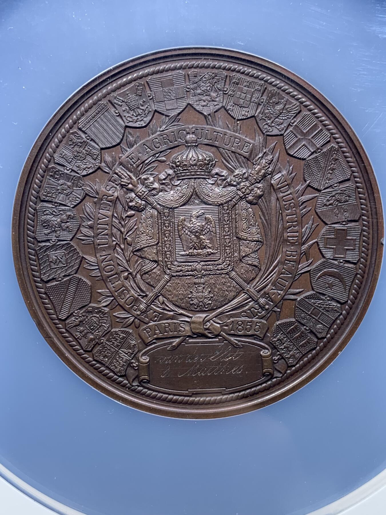 《竞宝斋》第444场 周日，周一，2场连拍 （全场包邮） NGC MS64BN 法国1855年巴黎世博会纪念大铜章，60mm，顶级高分。拿三章牌中的热门品种，20国徽章环绕波拿巴家族鹰徽，众星捧月，繁复华丽，记录拿破仑三世的巅峰时刻。手指边铭原铸品，加大加厚盒装