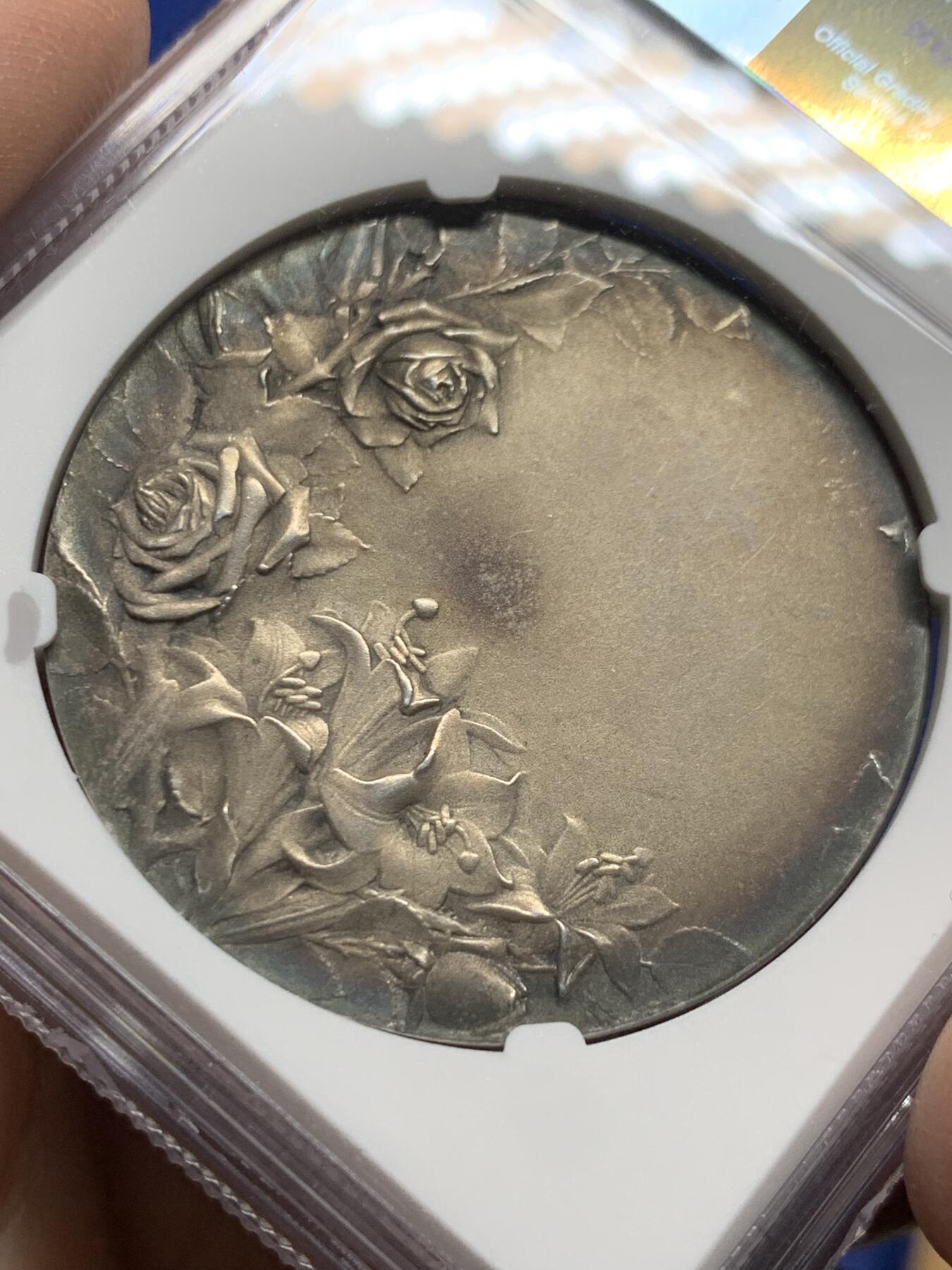 《竞宝斋》第444场 周日，周一，2场连拍 （全场包邮） NGC MS62 法国新艺术宗教婚礼稀有大银章，著名新艺术雕刻家：弗雷德里克-夏尔.维克托.德.韦尔农，以细腻的宗教题材浮雕著称。该章为更为稀少的背面无刻字版，适合新婚、结婚纪念刻字。正面场景：描绘yesu与使徒彼得、约翰（或抹大拉的马利亚）的互动FIDELI PERSTETIS AMORE拉丁语，意为**“你们对那忠信的恒守爱心”，背面：花卉：左下角的玫瑰（象征玛利亚的纯洁）与下方的百合（象征圣