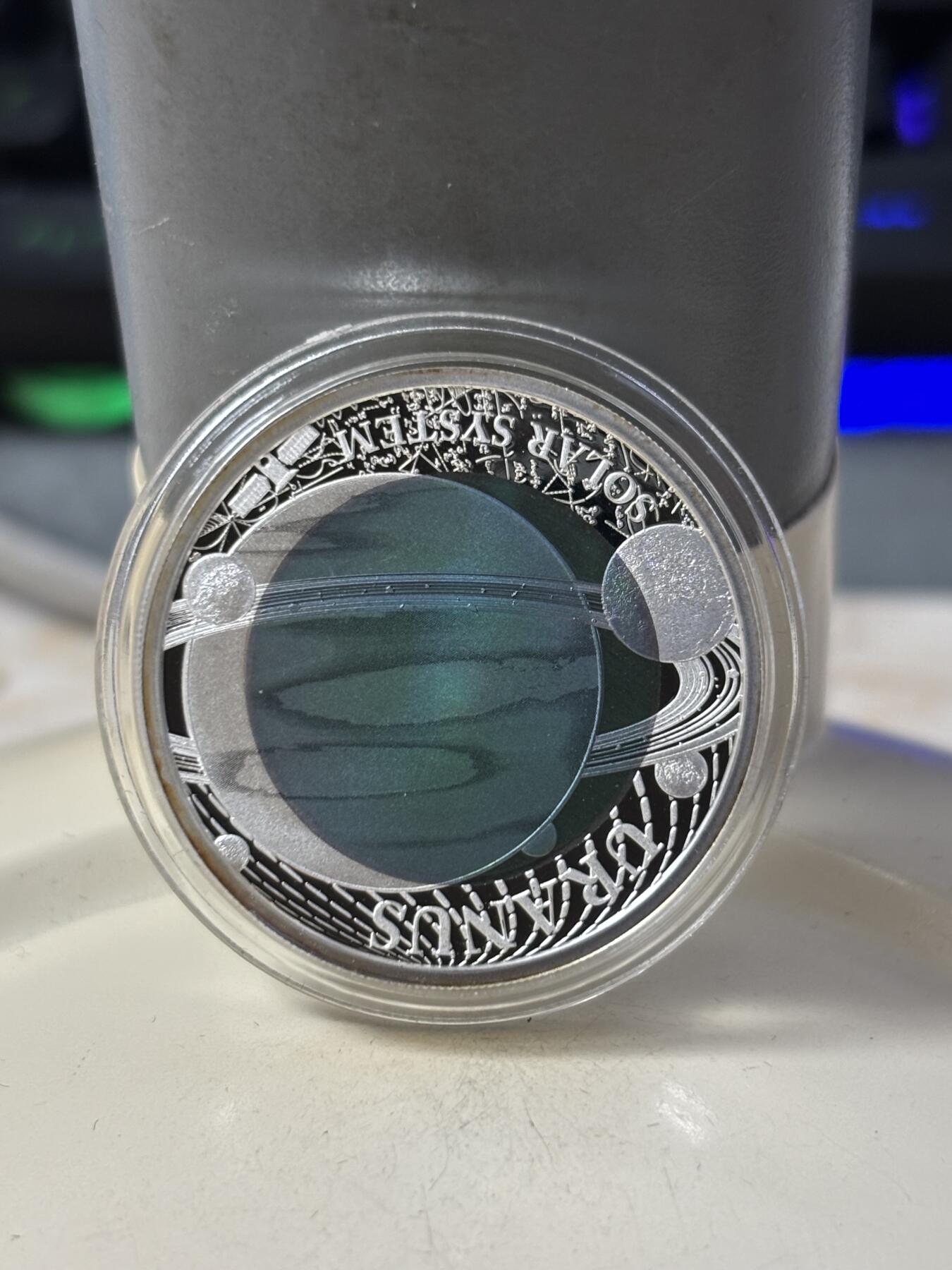 第184期拍卖 帕劳2018年太阳系系列2天王星镶蓝色铌金属彩银币，金属:999银/998铌，重量:15克(8.3克银/6.7克铌），发行：3000枚