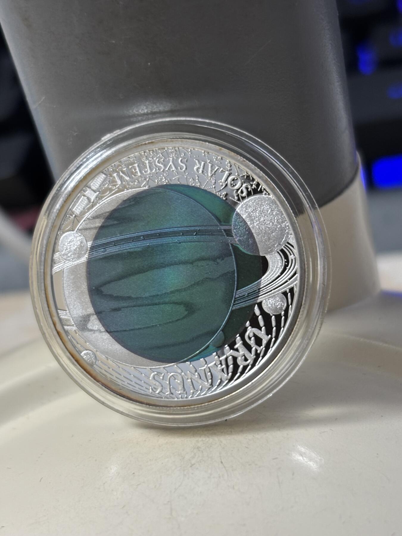 第184期拍卖 帕劳2018年太阳系系列2天王星镶蓝色铌金属彩银币，金属:999银/998铌，重量:15克(8.3克银/6.7克铌），发行：3000枚