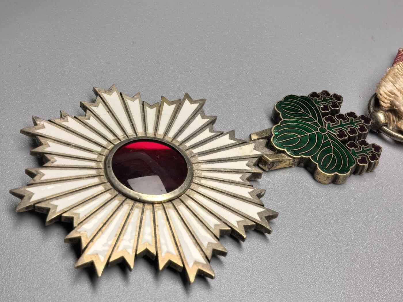 小驴勋章奖章收藏12月06日周六晚六点拍卖（珍爱和平，收藏战争，铭记历史，勿忘国耻，忠党爱国。有偿代拍，送拍规则在简介最后，参拍须阅读规则后再参拍，关系到运费包装发货时效真假辨别等关键信息，拍卖时不再发原图，看大图店主微信码在拍卖店铺介绍里） 早期无花结勋四等旭小绶日章，凹珐琅，紫红色绶带，侧面打“匕”标，银质七宝烧，青色部分有些许磕碰