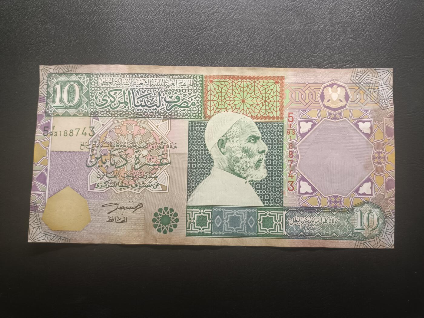 2025十二月第一期，总206期 【夜】利比亚2002版10第纳尔AUNC边黄，民族英雄穆斯塔法和人群聚集