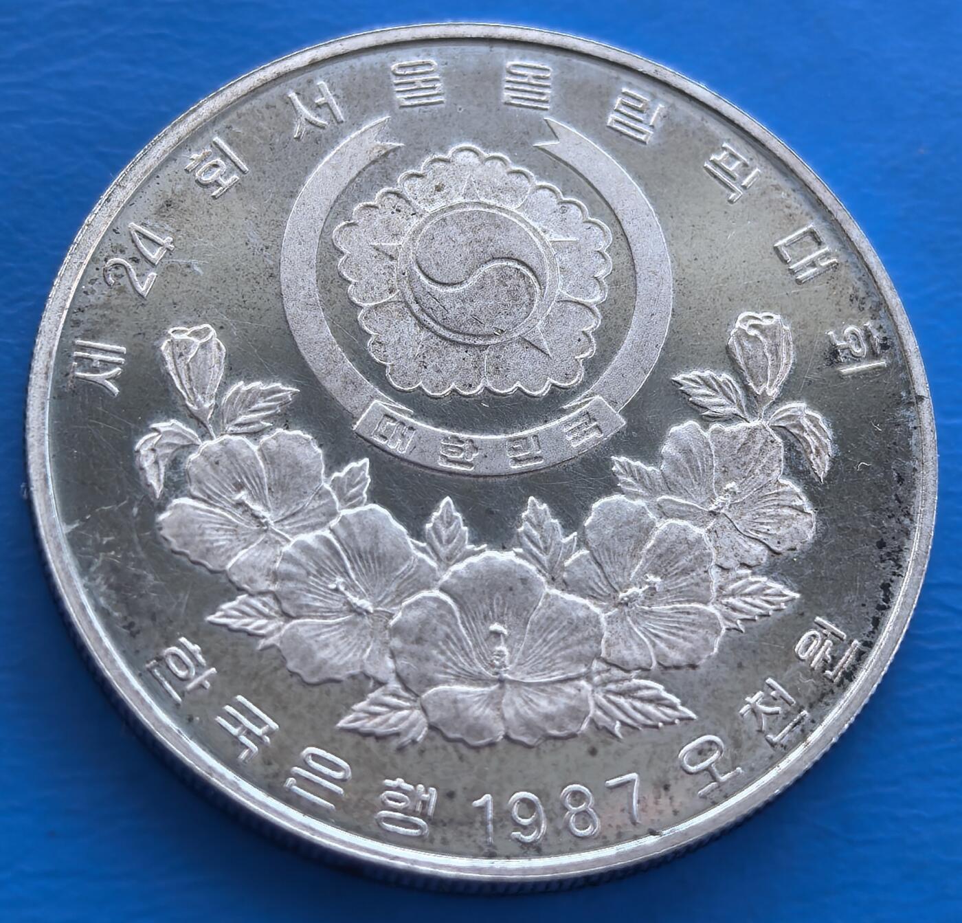 外国优质老铜币银币持续添加中，周六九点倒数截拍，满百包邮，可寄存半年，喜欢朋友微信扫描二维码可直接参拍 韩国1987年奥运会会馆5000元高银大银币