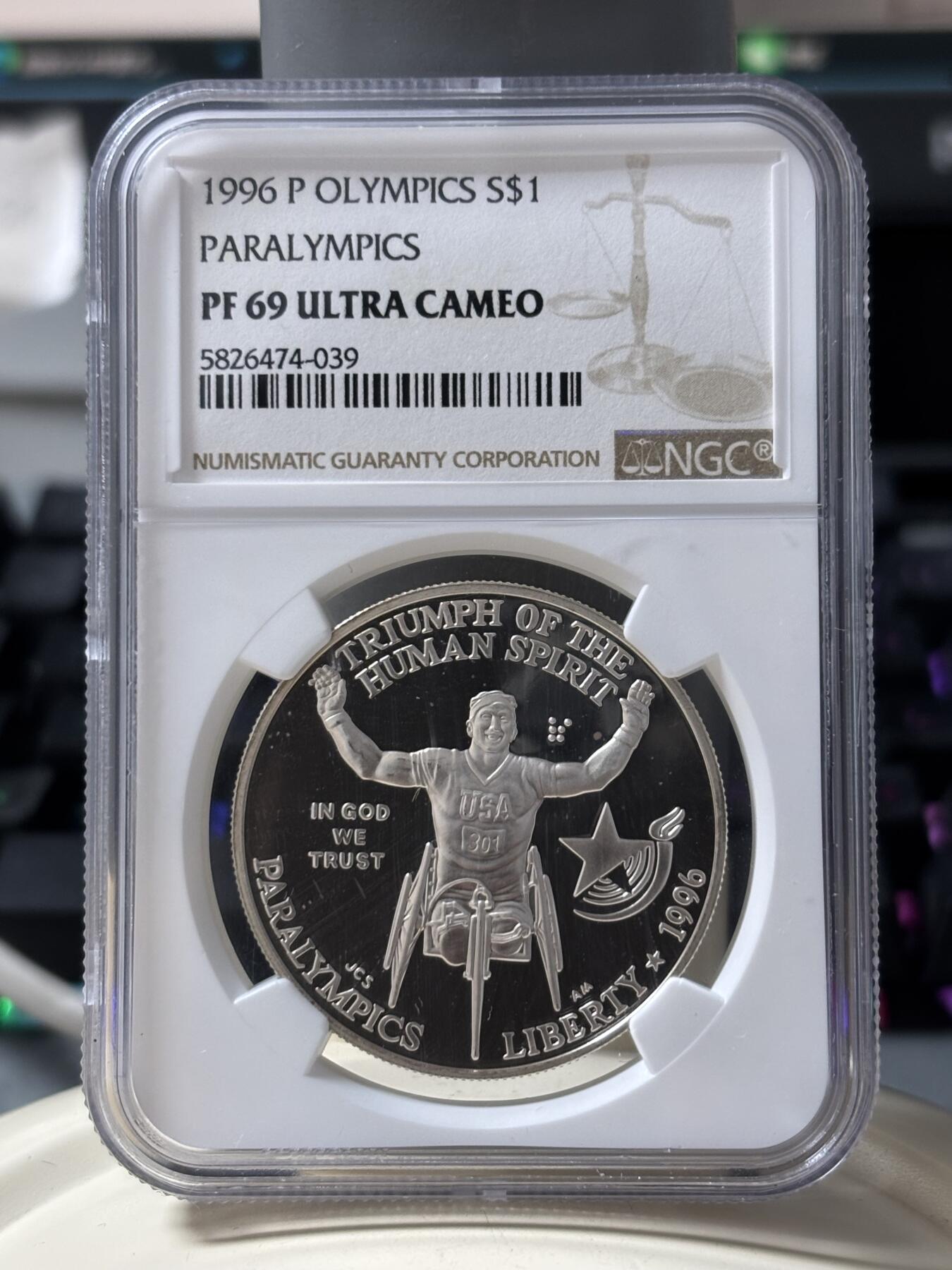 第185期拍卖 获奖美国1996年亚特兰大残奥轮椅赛银币NGC-PF69，900银，26.72克，此币荣获世界硬币大奖赛