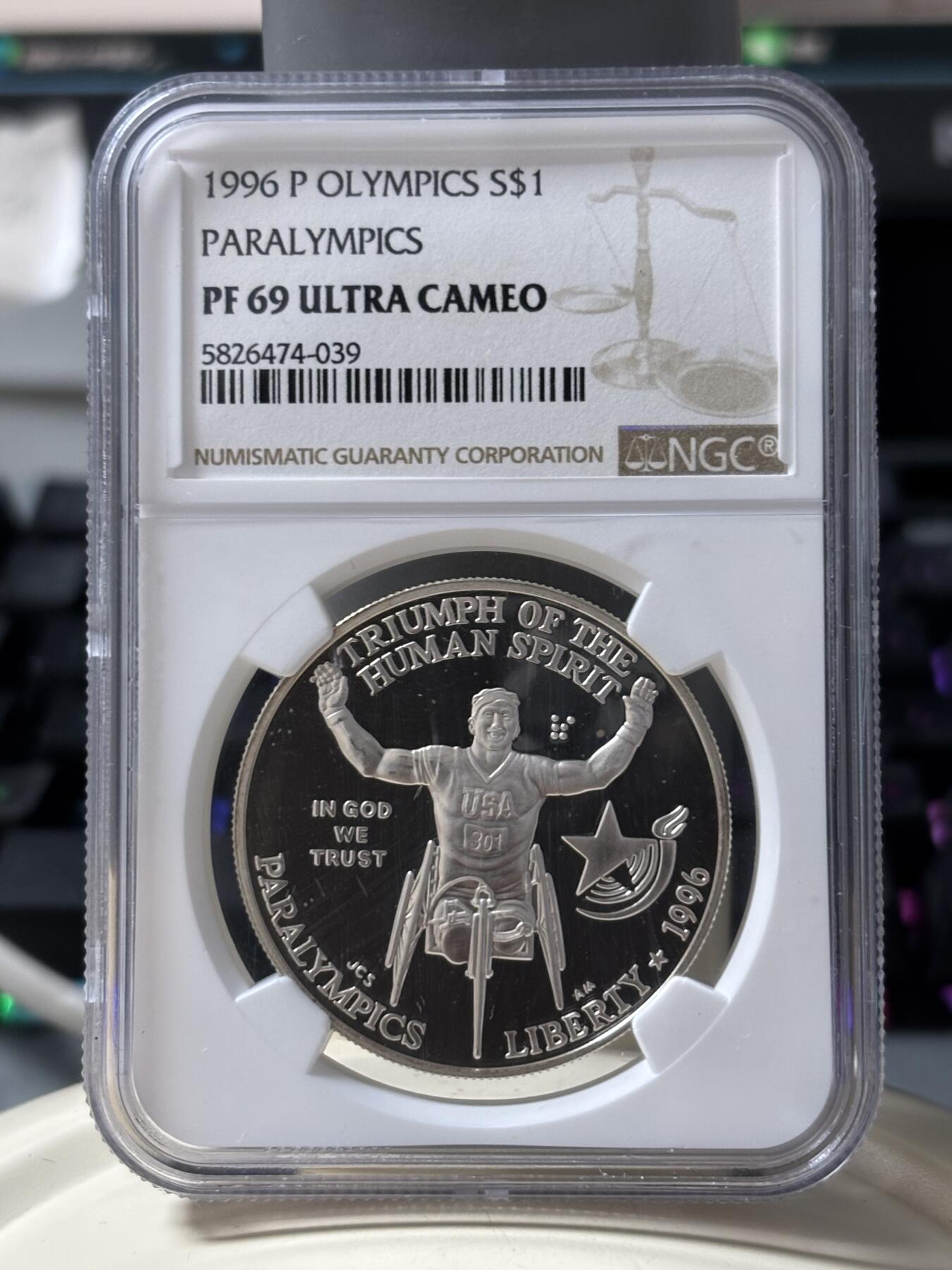 第185期拍卖 获奖美国1996年亚特兰大残奥轮椅赛银币NGC-PF69，900银，26.72克，此币荣获世界硬币大奖赛