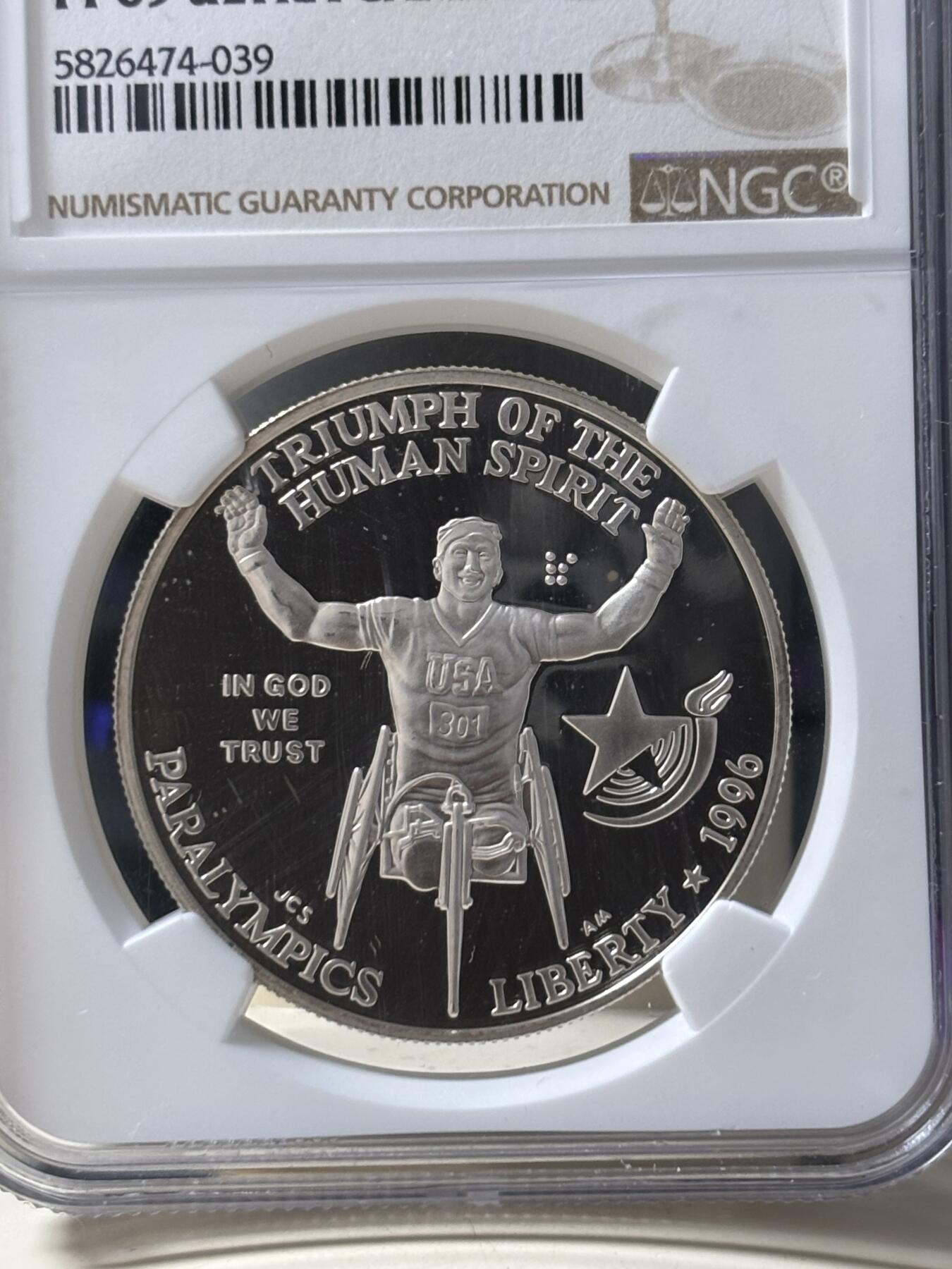 第185期拍卖 获奖美国1996年亚特兰大残奥轮椅赛银币NGC-PF69，900银，26.72克，此币荣获世界硬币大奖赛