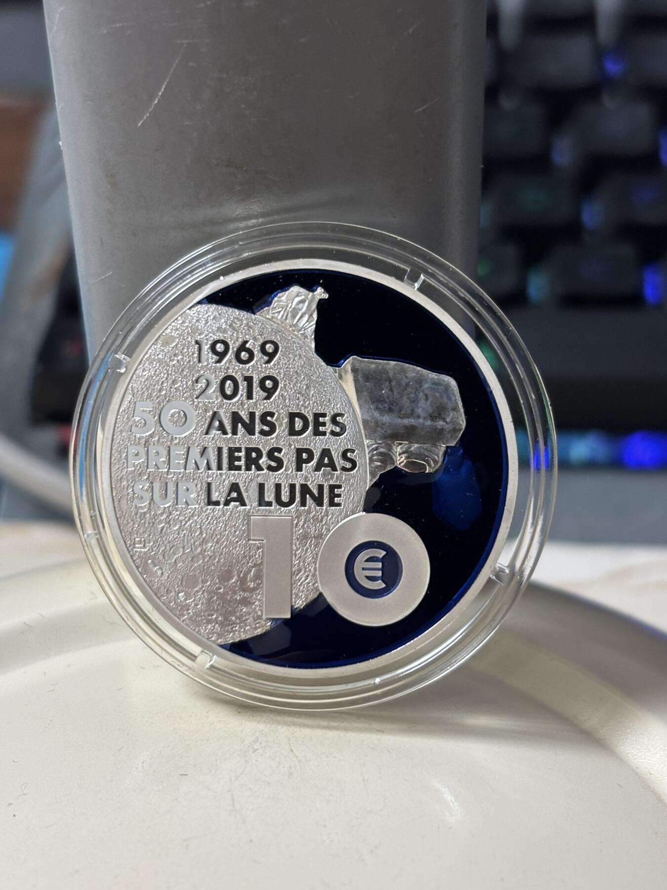 第185期拍卖 法国2019年人类登月50周年镶嵌特殊物质银币，金属:900银+特殊彩色物质，重量:17.3克+17.9克，直径:38毫米，发行：5000枚