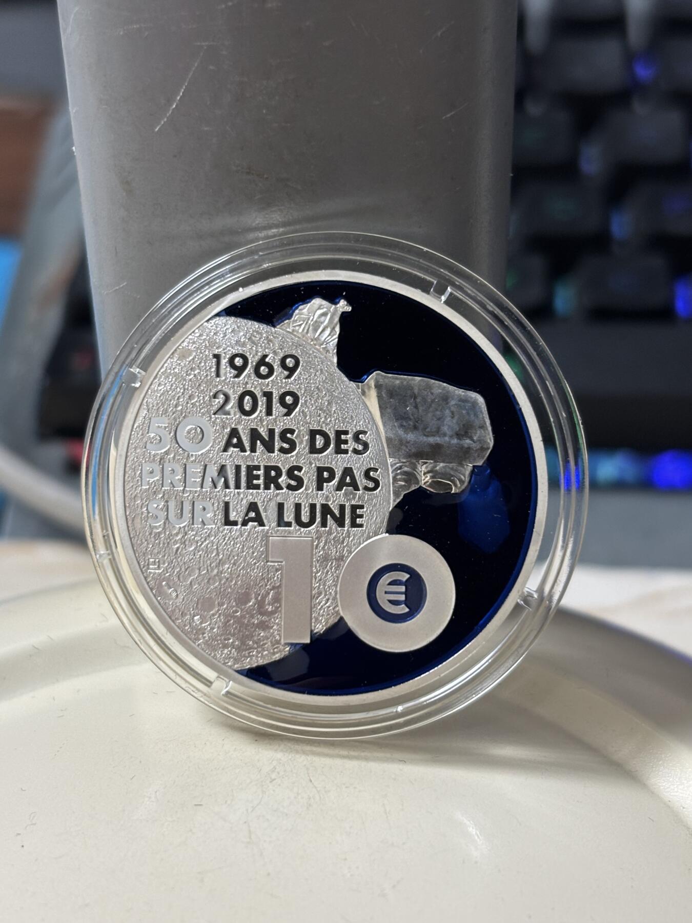 第185期拍卖 法国2019年人类登月50周年镶嵌特殊物质银币，金属:900银+特殊彩色物质，重量:17.3克+17.9克，直径:38毫米，发行：5000枚