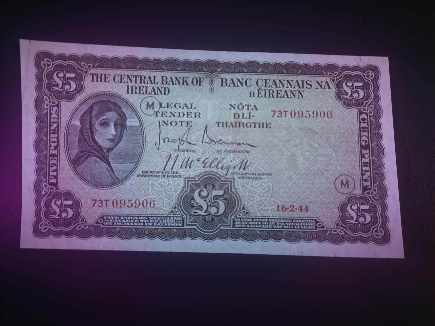 2025十二月第二期，总207期 爱尔兰1944年5镑流通好品XF，早期下方有英爱两国货币互换协议的版本，以及加盖二战时期印刷的紧急识别字母，爱尔兰人格化象征“拉维利夫人”，稀有战时中高面值
