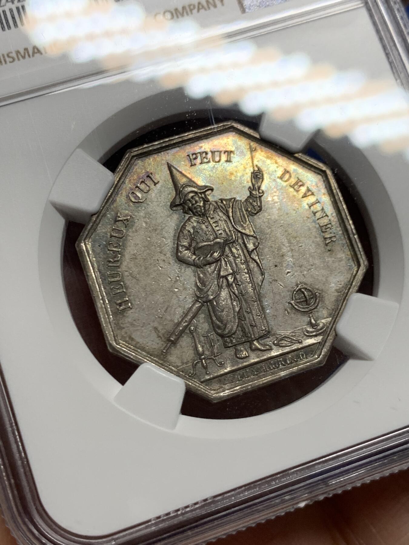 《竞宝斋》第446场 周日，周一，2场连拍 （全场包邮） NGC MS61 罕见魔术师及双海妖银质八角代币，早期无边铭。出分不易值得收藏，铭文：“害怕虚荣的快乐带来的欺骗性诱惑”＆“能猜出答案的人是幸福的”