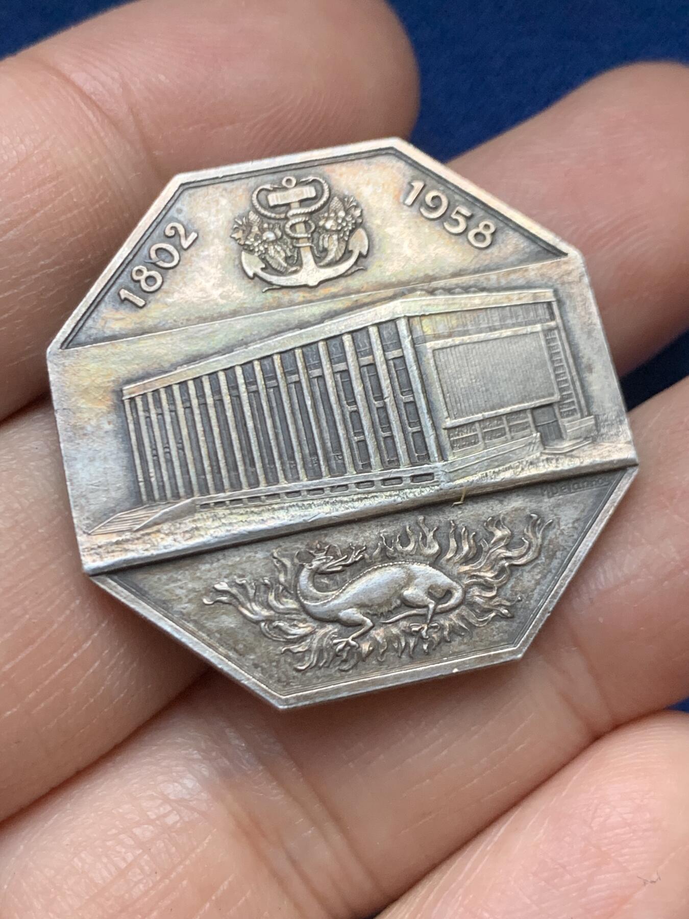 《竞宝斋》第446场 周日，周一，2场连拍 （全场包邮） 法国1958年勒阿弗尔商会八角银质代币 19.3克 32mm 丰饶角1银标  正面：十八世纪勒阿弗尔港全景，停泊着多艘帆船； 背面：锚形图案标注年份「1802-1958」，火焰中小火龙图案，中央为商会大楼景观；下方设计师签名「M·德尔努瓦」