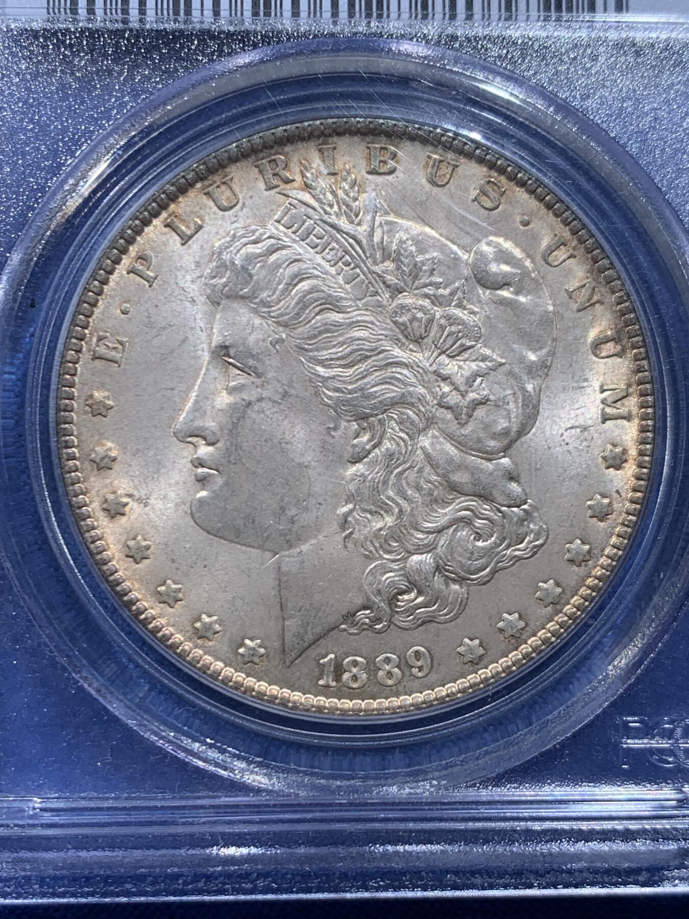 《竞宝斋》第446场 周日，周一，2场连拍 （全场包邮） PCGS MS63 美国1889年摩根银币，老白盒严评，状态很好，带点环彩。背面支撑四角有磕