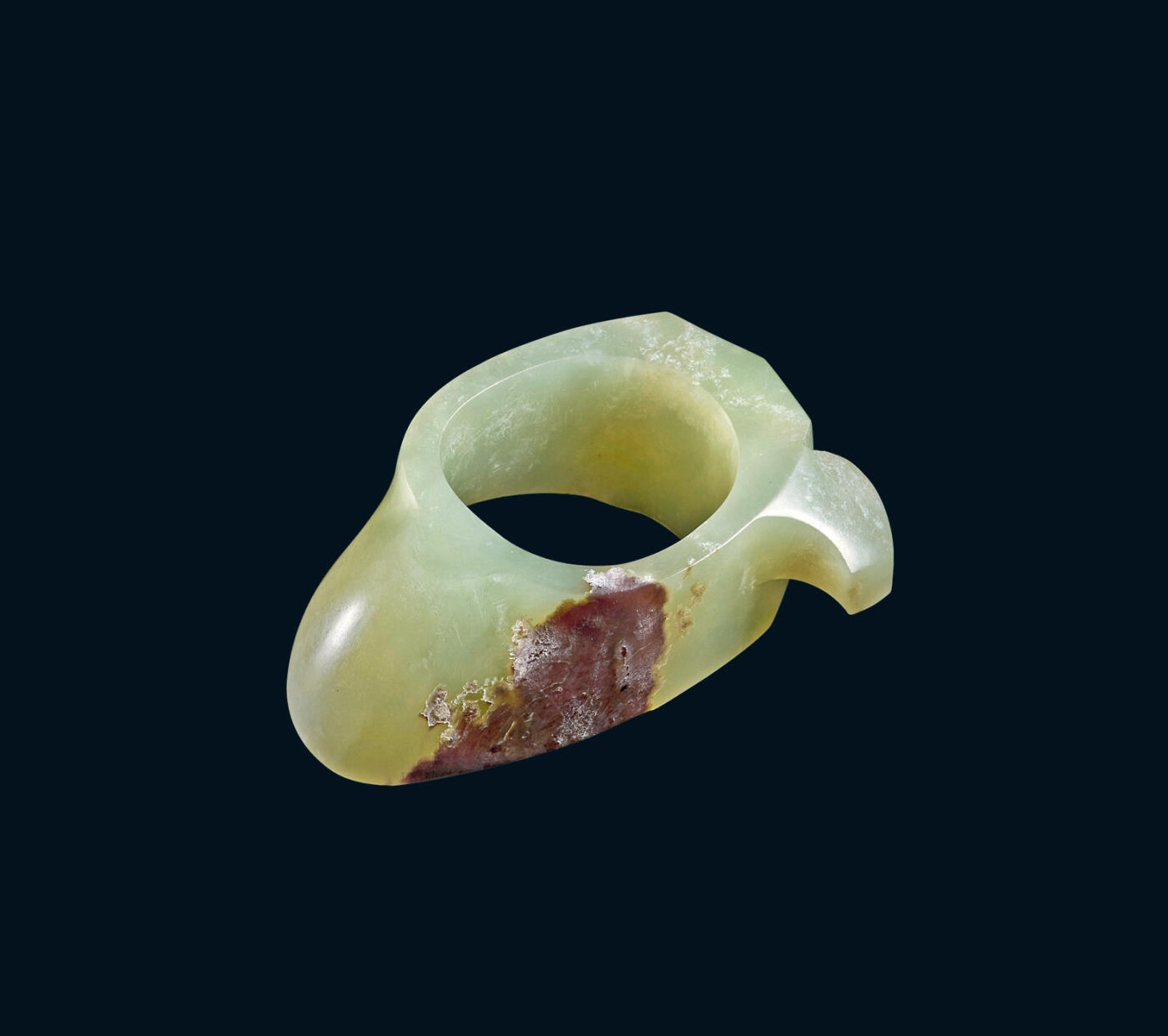 上海匡时2025年秋季拍卖会 中国历代钱币 铜镜专场 玉韘 韘为中国古代北方少数民族的佩饰之物，用以拉弓射箭、吩帨之类，宋代沈括《梦溪笔谈》谓：「窄袖绯绿，短衣，长靿靴，有碟带，皆胡服也。」此件为黄玉质地，用料考究，莹润华丽，光气纯熟，局部有红沁，周身光素无纹，更显玉质的华贵。