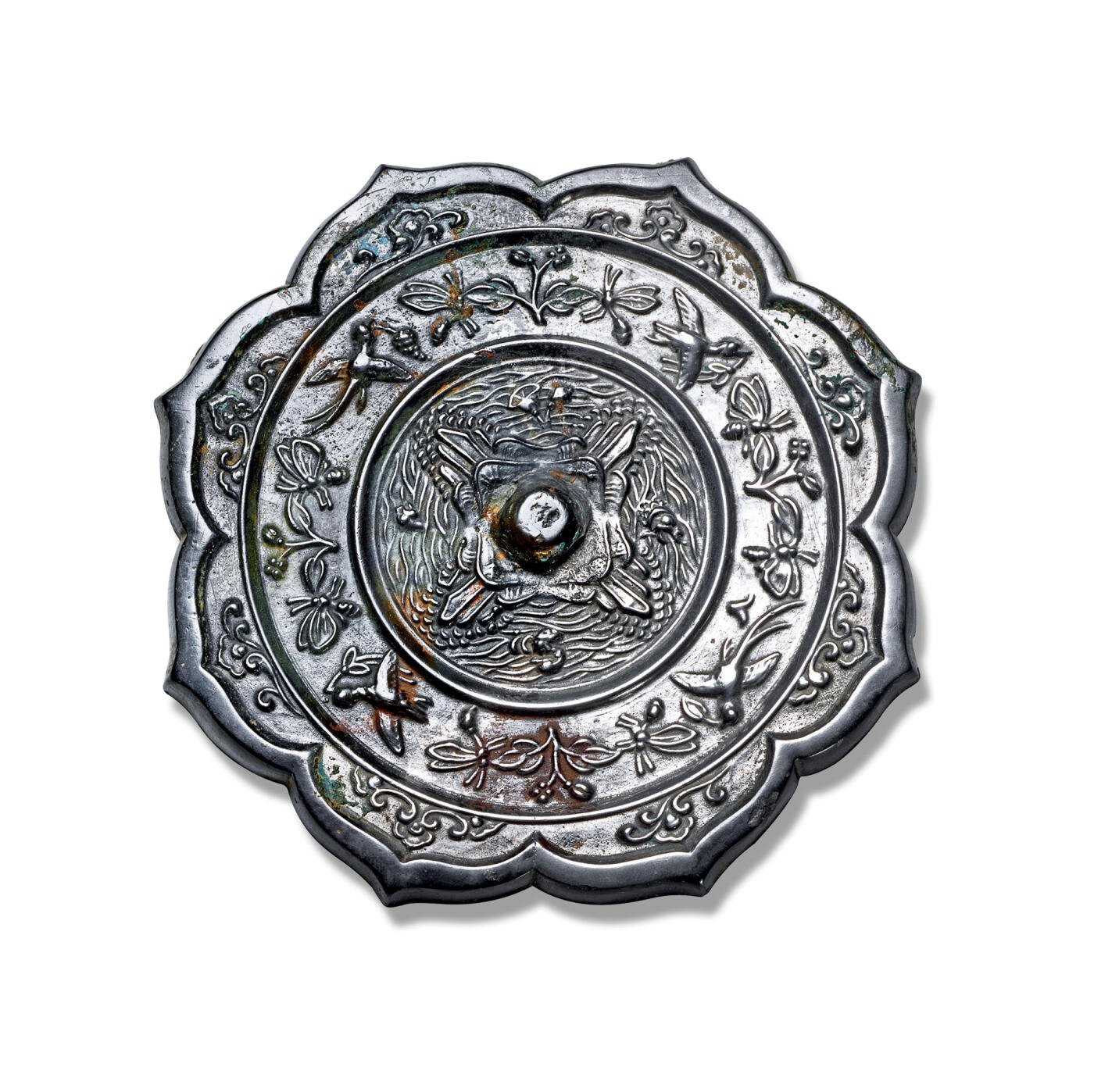 上海匡时2025年秋季拍卖会 中国历代钱币 铜镜专场 五岳花鸟镜 八出菱花形，圆钮，四岳钮座。纹饰自镜钮向外分为三圈，内区为四座高山环绕镜钮成十字形对称分布，四座山峰间满布层层翻卷的水波纹，其间饰摩羯、水禽、花卉和瑞兽纹。中区环饰禽鸟、花卉、蜂蝶纹。外区八瓣镜缘内花卉纹和云气纹相间环绕。白光，有冲。铜镜中四座山峰围绕镜钮的纹饰造型称为“五岳图”，亦称“五岳真形图”，是道教的御符，可防御一切刀兵水火之祸和妖魔鬼怪。