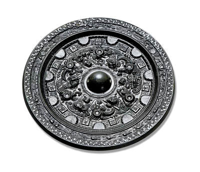 上海匡时2025年秋季拍卖会 中国历代钱币 铜镜专场 - 半圆方枚神人神兽镜 圆形，圆钮，圆钮座。主体纹饰采用高浮雕技法饰一周浮雕神人神兽图案，以四只神态各异的神兽为界，将纹饰分为四组，以钮为中心放射性布局。外区有凸起的半圆和方枚相排列，半圆侧面亦饰以极精致的半圆纹饰，与方枚之间的空白皆以点状细小乳钉填充，精美异常。每一方枚均有一字连读为：三羊自有己余去不羊宜古。方枚之外则是一圈细密的锯齿纹。镜缘处内圈饰一周神人驾龙车，乘鸾鸟，腾云驾雾出巡图。