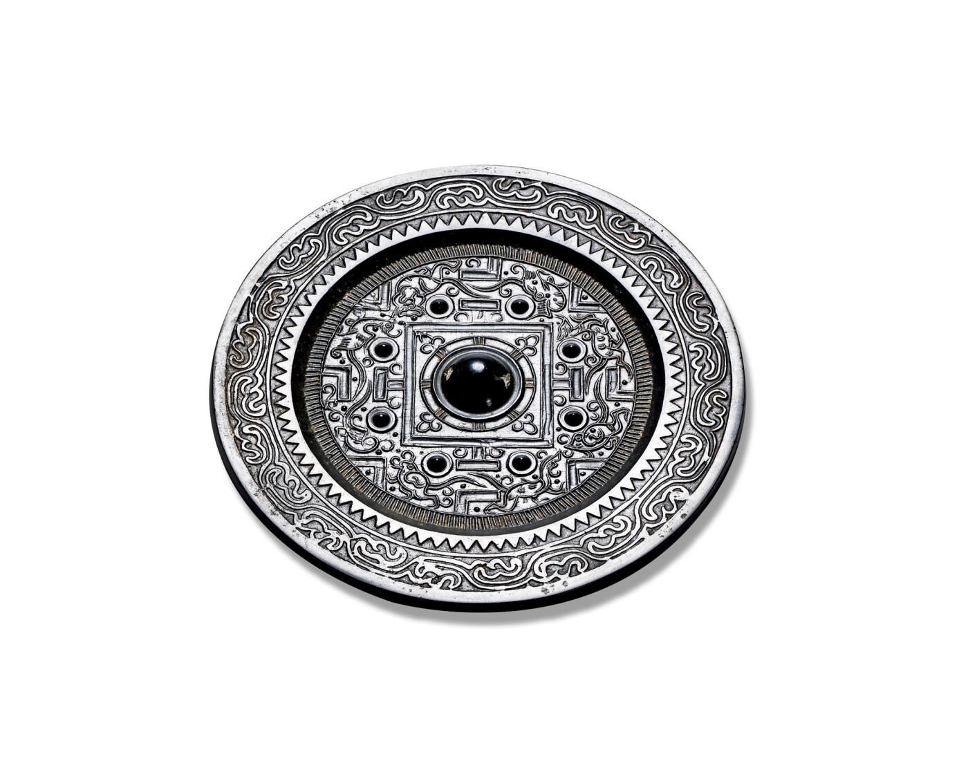 上海匡时2025年秋季拍卖会 中国历代钱币 铜镜专场 神兽规矩镜 圆形，圆钮，圆钮座，双线凹面方格外，四“T”纹两侧有八乳钉与规矩纹，将主纹饰分为四方八区，其间以线工绘饰八组瑞兽，形态饱满，线工流畅，镜缘一周锯齿纹与流云纹，此镜保存完好，状态佳，铜质精良，镜体干净，黑漆古状态，收藏住品。