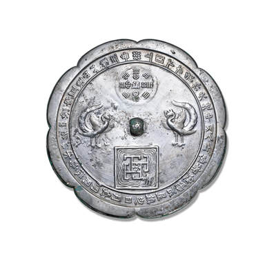 上海匡时2025年秋季拍卖会 中国历代钱币 铜镜专场 - 双鸾道教铭文镜 八出菱花形，圆钮，主题纹饰为两只对立的鸾鸟，鸾为凤凰之属，象征吉祥；上侧圆形八卦图案，中间“镇”字铭文，“镇”字上下日月纹，左右为星辰；下侧为方形图案，里边有水波纹和代表五岳的方块图案，上圆下方，意为天圆地方，五岳四渎。镜缘一周铭文：“上圆下方，象于天地，中列八卦，备着阴阳，辰星镇定，日月贞明，周流为水，以名四渎，内置连山，以旌五岳。”此铭文十分细致的解读了镜中纹饰，将道教文化展现