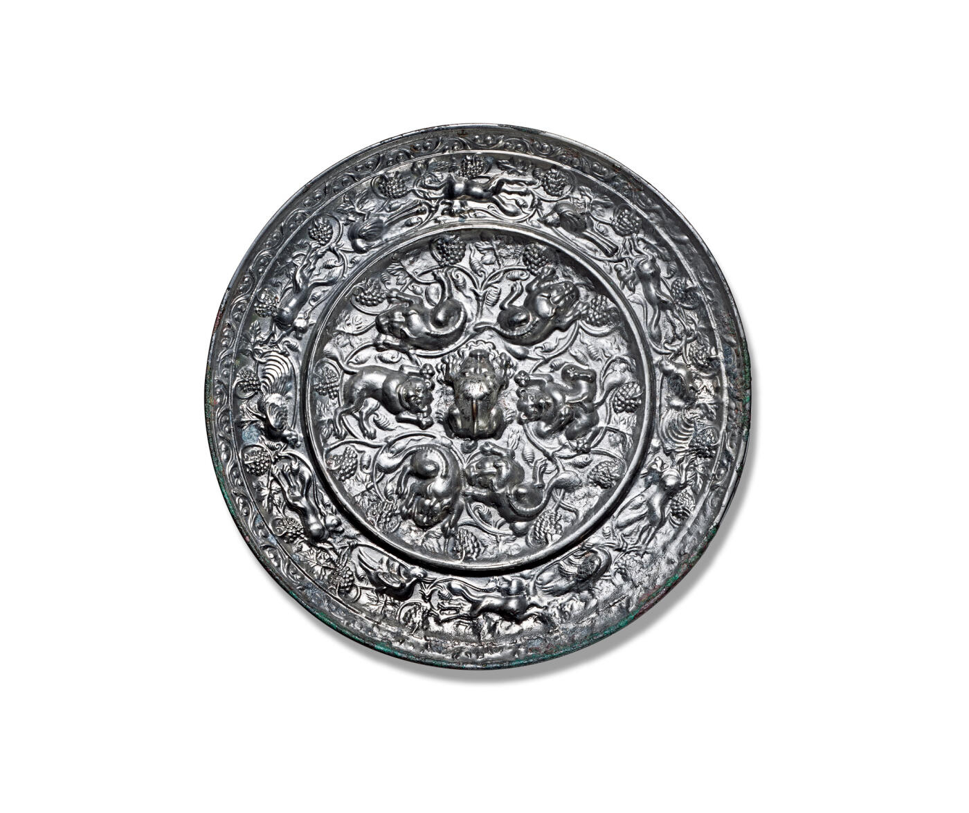上海匡时2025年秋季拍卖会 中国历代钱币 铜镜专场 海兽葡萄镜 圆形，伏兽钮。伏兽形体丰腴，造型精巧，神态刻画清晰，风格富丽华美。镜背以凸棱划分为内外两区：内区环饰六只姿态各异的瑞兽，浮雕立体感强，构图富于变化，情态生动，将具有情节性的画面巧妙融入装饰意趣之中，艺术表现力突出。瑞兽周围葡萄叶蔓缠绕，共同营造出一幅悠然恬静、生机盎然的自然景致。外区饰以跑兽与瑞鸟，掩映于繁密的葡萄枝蔓与果实之间。瑞兽体态丰盈灵动，禽鸟翎羽飘逸，姿态优雅挺拔。果实累累，