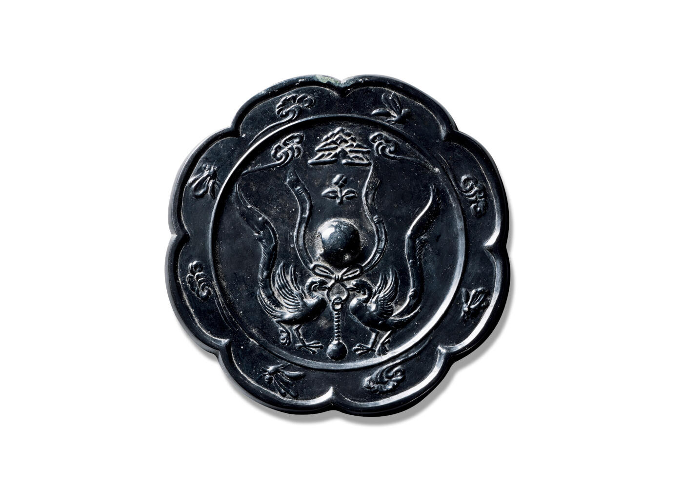 上海匡时2025年秋季拍卖会 中国历代钱币 铜镜专场 双鸾衔绶纹镜 八出葵花形，圆钮。钮左右双瑞鸟对峙口衔绶带单爪站立，钮上方为山川、花卉、祥云纹饰，缘八瓣内饰蝴蝶纹和祥云纹相间分布一周。