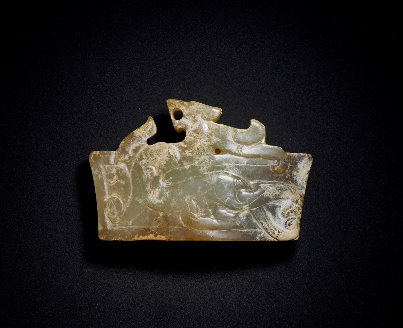 上海匡时2025年秋季拍卖会 中国历代钱币 铜镜专场 剑珌 剑珌精美细润，沁色鲜明饱满浓厚，局部深浅沁交错、渐层通体红沁，光气莹润，适宜盘玩。剑珌主体呈束腰梯形，顶部打孔，纹饰雕琢工整、流畅，一面雕琢高浮雕蟠螭纹，攀附于剑珌之上，螭龙头型似虎，穿过底部咬住剑珌边缘，身躯矫健，四肢有力，尾部分叉，呈纽丝状卷曲，生动灵巧。一面装饰几何形云矩纹。剑珌为剑饰器中相对稀少之品项，高浮雕出廓纹饰为玉中档次极高的纹饰类型，该剑珌器物纹饰复杂，造型精美，极具收藏价值