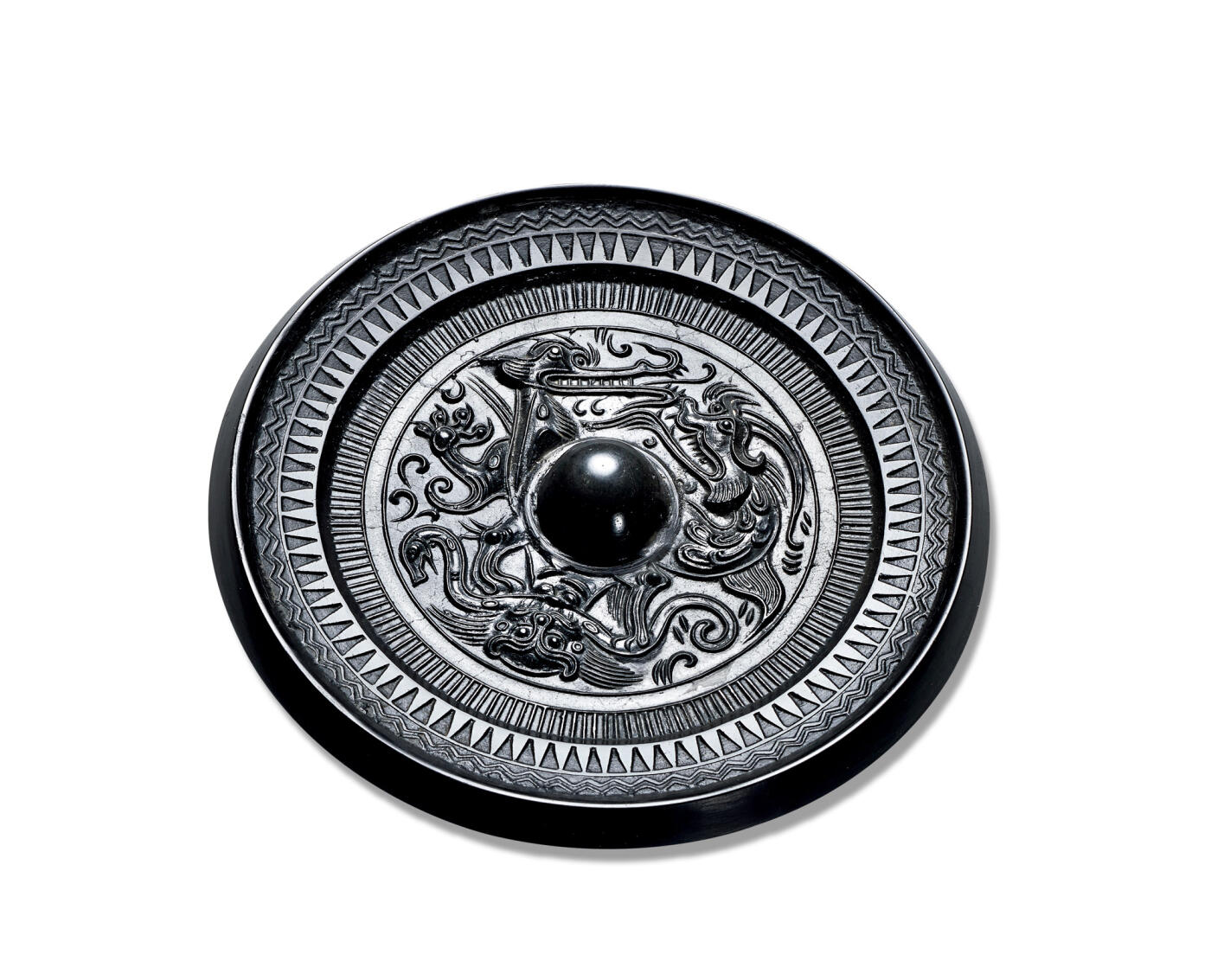 上海匡时2025年秋季拍卖会 中国历代钱币 铜镜专场 少见“鳄鱼”龙虎镜 圆形，圆钮，圆钮座。主纹饰区内为对峙的鳄鱼和龙，以及一虎纹环绕镜钮。鳄鱼、龙以及虎的身躯被压于镜钮之下，主纹饰外环饰一周栉齿纹，镜缘上饰一周锯齿纹和一周双线波浪纹。全镜黑漆古，图案精细，品相完好，鳄鱼纹饰在龙虎镜上极为少见，乃收藏珍品。