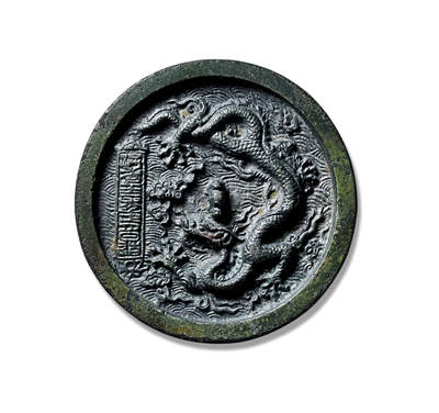 上海匡时2025年秋季拍卖会 中国历代钱币 铜镜专场 - 洪武二十二年单龙镜 圆形，山形钮，镜背施浮雕之技装饰一条修长苍健、气势磅礴的龙纹，背脊明显，鳞甲清晰，四肢舒展作凌空之态，地章满饰海水纹。龙呈双角之姿，瞠目隆眉，且为五爪之象，等级极高，左侧莲花之间置铭文方格，上书篆体“洪武二十二年正月日造”，为洪武龙纹的标准器，包浆古朴熟美，完美品相。