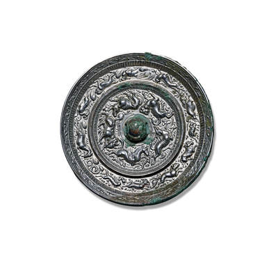 上海匡时2025年秋季拍卖会 中国历代钱币 铜镜专场 - 天马跑兽十二生肖镜 圆形，圆钮，圆钮座。一周带有三角锯齿纹的凸棱将镜背纹饰分为内外两区。内区一匹带双翅的天马与四只跑兽形态生动，天马身资矫健似奔跑飞翔状，各跑兽动感十足，四肢矫健，形体丰腴，或闲庭信步，或低头觅食，或回首顾望，或奋蹄疾驰，动物形体刻画细腻，构图变化多端，情态不一。天马题材在铜镜纹饰上并不多见。外区一圈十二生肖瑞兽纹，按地支顺时针排列，采用浮雕铸造，生肖形象生动，整镜通体白光，纹饰华