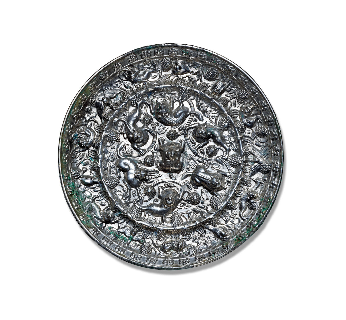 上海匡时2025年秋季拍卖会 中国历代钱币 铜镜专场 海兽葡萄镜 圆形，伏兽钮，采用高浮雕的表现技法，一圈凸弦纹将镜背纹饰分成内外两区。内区六瑞兽环绕镜钮攀援嬉戏，瑞兽有的匍匐向前，有的抓咬藤蔓，有的昂首阔步，有的回首躬身。造型各不相同。其间缀葡萄叶蔓和果实。外区饰一周瑞兽相间禽鸟，栖息在葡萄叶蔓之间，其间点缀累累的葡萄纹。铜镜铸造精美，纹饰生动，尤其是瑞兽毛发丝丝可辨，卷曲的毛发突显柔软质感，瑞兽脊梁亦清晰可数，筋肉遒劲有力。禽鸟羽翼丰满，葡萄枝叶