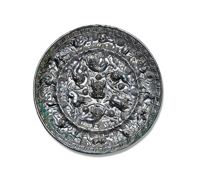 上海匡时2025年秋季拍卖会 中国历代钱币 铜镜专场 - 海兽葡萄镜 圆形，伏兽钮，采用高浮雕的表现技法，一圈凸弦纹将镜背纹饰分成内外两区。内区六瑞兽环绕镜钮攀援嬉戏，瑞兽有的匍匐向前，有的抓咬藤蔓，有的昂首阔步，有的回首躬身。造型各不相同。其间缀葡萄叶蔓和果实。外区饰一周瑞兽相间禽鸟，栖息在葡萄叶蔓之间，其间点缀累累的葡萄纹。铜镜铸造精美，纹饰生动，尤其是瑞兽毛发丝丝可辨，卷曲的毛发突显柔软质感，瑞兽脊梁亦清晰可数，筋肉遒劲有力。禽鸟羽翼丰满，葡萄枝叶