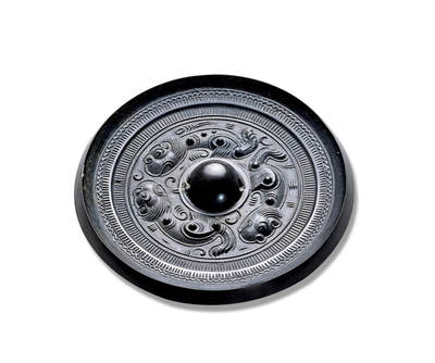 上海匡时2025年秋季拍卖会 中国历代钱币 铜镜专场 - 三虎镜 圆形，圆钮，钮周浮雕三虎环绕。其中两虎相对，一虎尾随，虎姿躬背曲尾，器宇轩昂，形态生动传神。边缘饰栉齿纹与双周折线纹。整体皮壳为黑漆古，纹饰塑造细腻，工艺精湛。三虎题材较为少见，此镜品相极佳，实为难得。