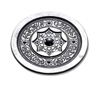 上海匡时2025年秋季拍卖会 中国历代钱币 铜镜专场 - 四乳变形凤纹镜 圆形，圆钮。十二连珠纹底座钮座外饰四凤鸟纹及乳钉草叶纹，钮座外有一周栉齿纹与一周内向八连孤，主纹饰为八连珠纹底座四乳钉间饰八组用弧线勾勒的抽象鸟纹图形，周边一周栉齿纹，素面宽缘。此镜图形怪异夸张，镖修条婉转繁缛，通体黑漆古，亮可鉴人。