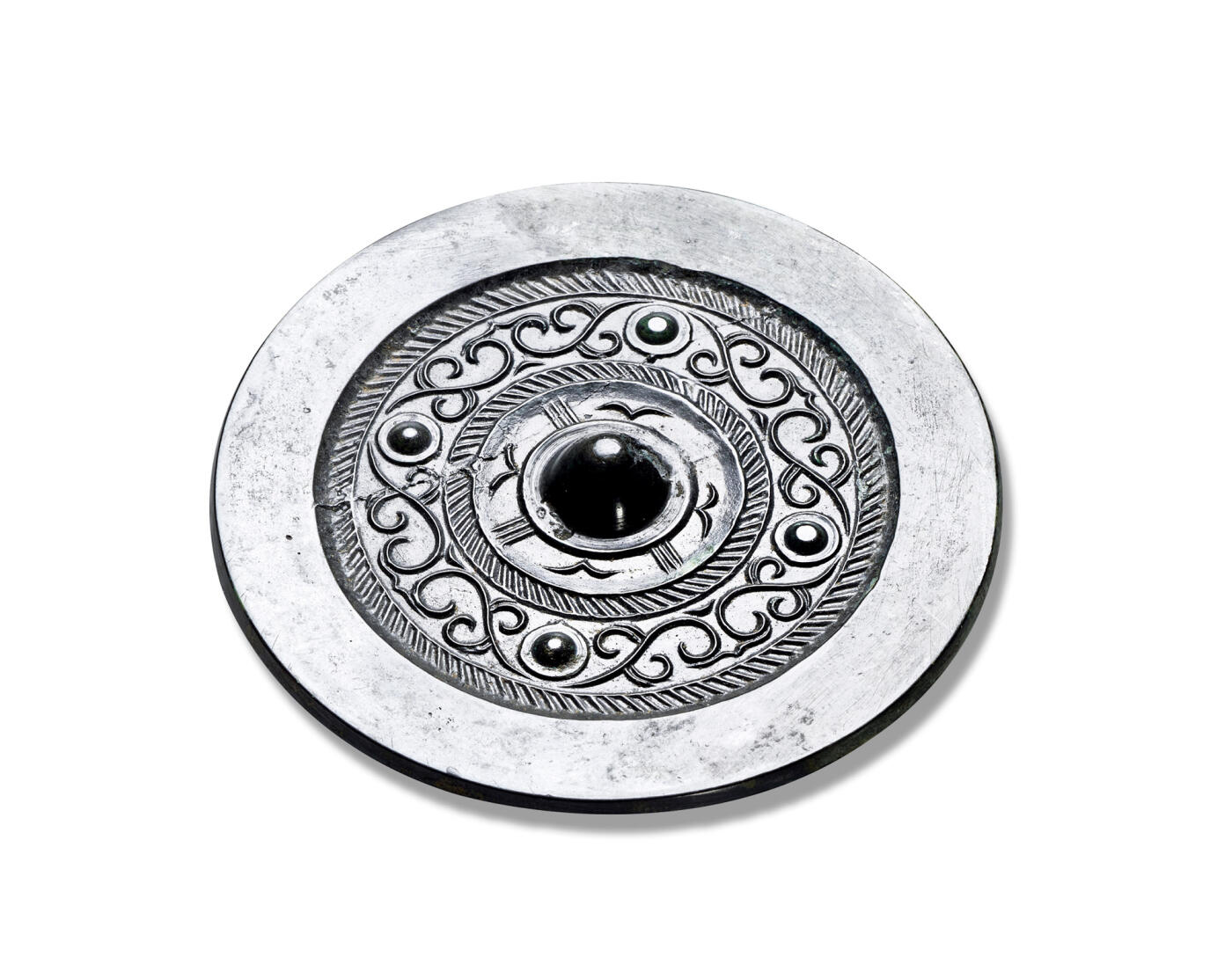 上海匡时2025年秋季拍卖会 中国历代钱币 铜镜专场 四乳缠枝纹镜 圆形，圆钮，圆钮座。主纹饰为双缠枝纹分布在两周栉齿纹间，以四枚圆座乳钉间隔，镜体呈黑漆古皮壳，干净简洁，线条刻画细腻，甚为美观。